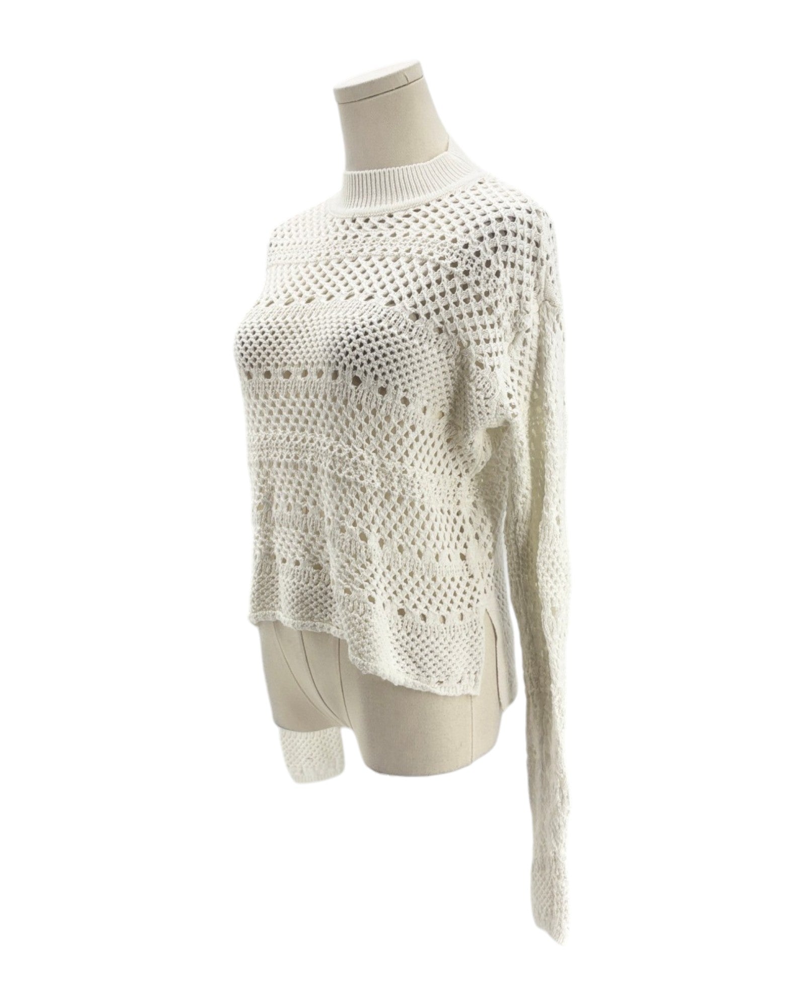 White textured sweater on a mannequin against a white background
