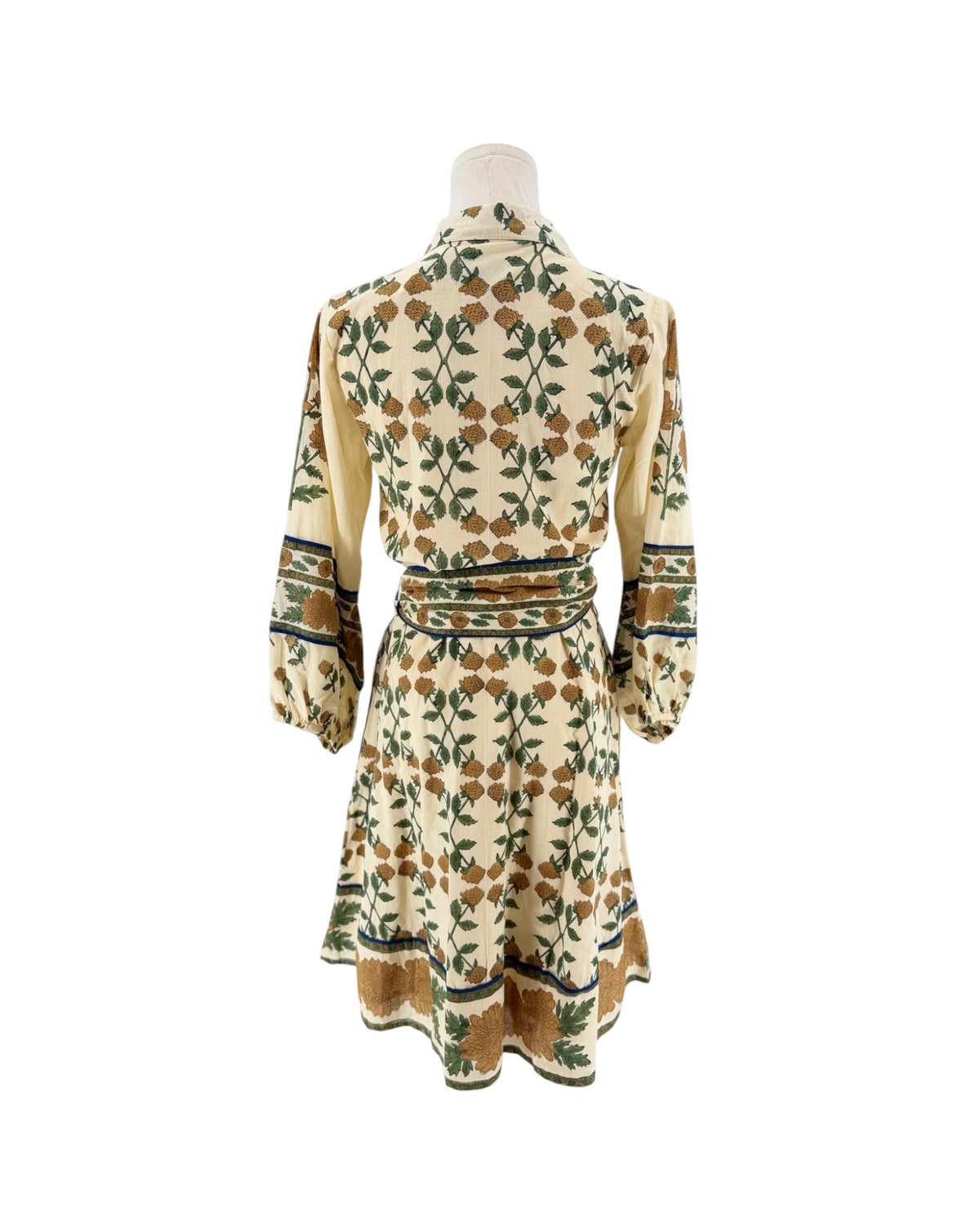 A cream-colored long-sleeve dress with a green and brown floral pattern, displayed on a mannequin from the back against a white background.