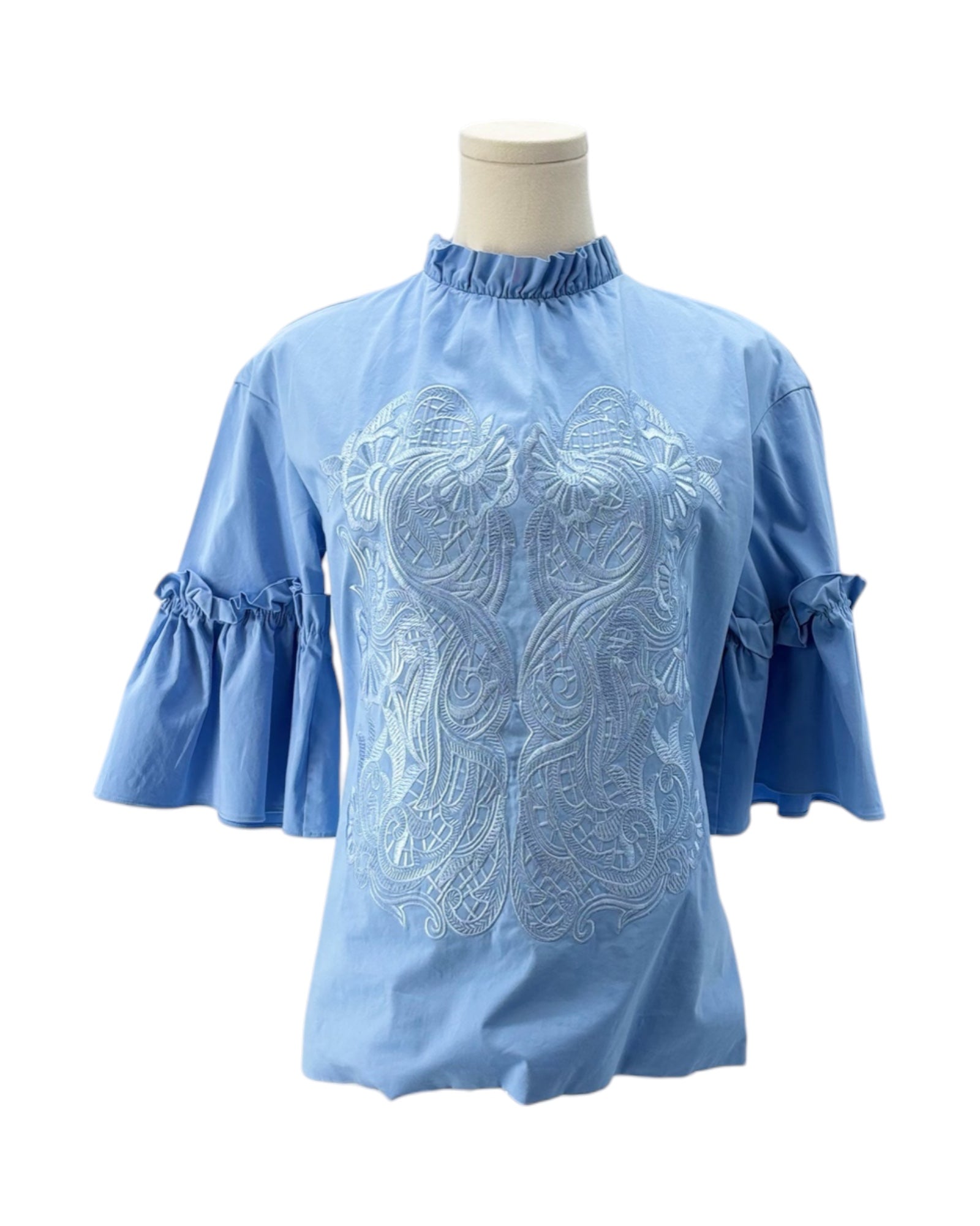 Blue blouse with intricate white embroidery on a mannequin against a white background