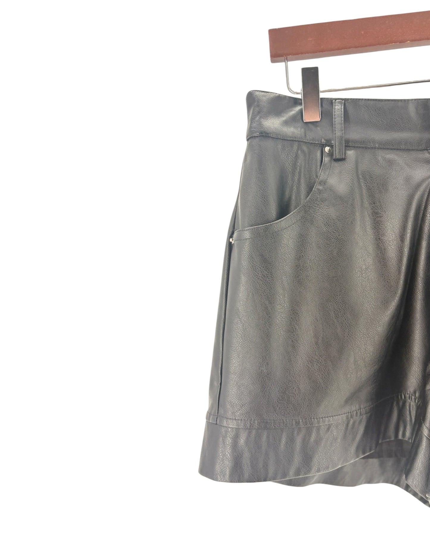 Black shorts on a hanger against a white background
