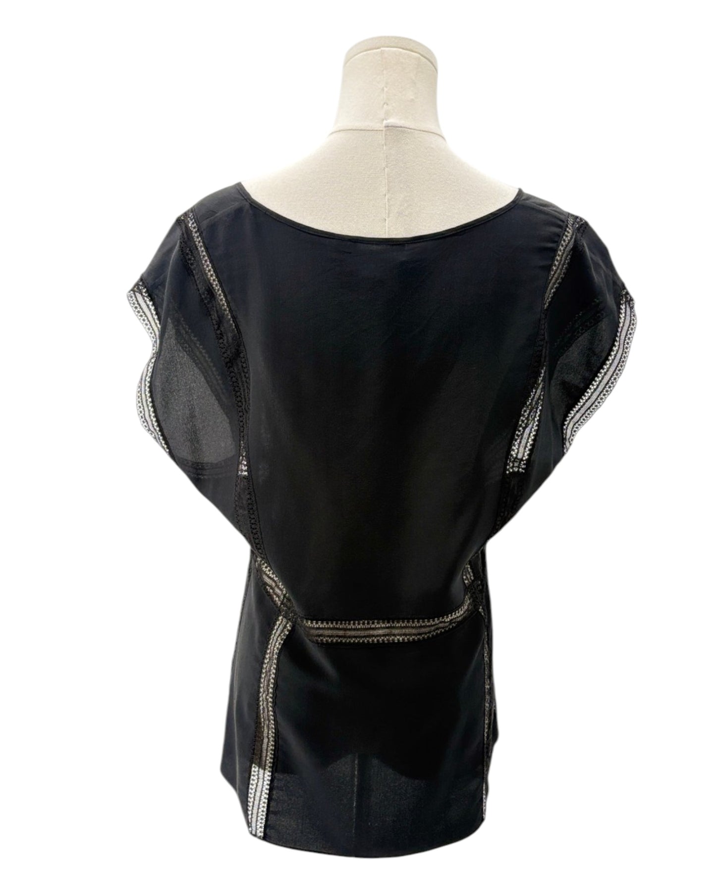 Black top with sheer sleeves on a mannequin against a white background