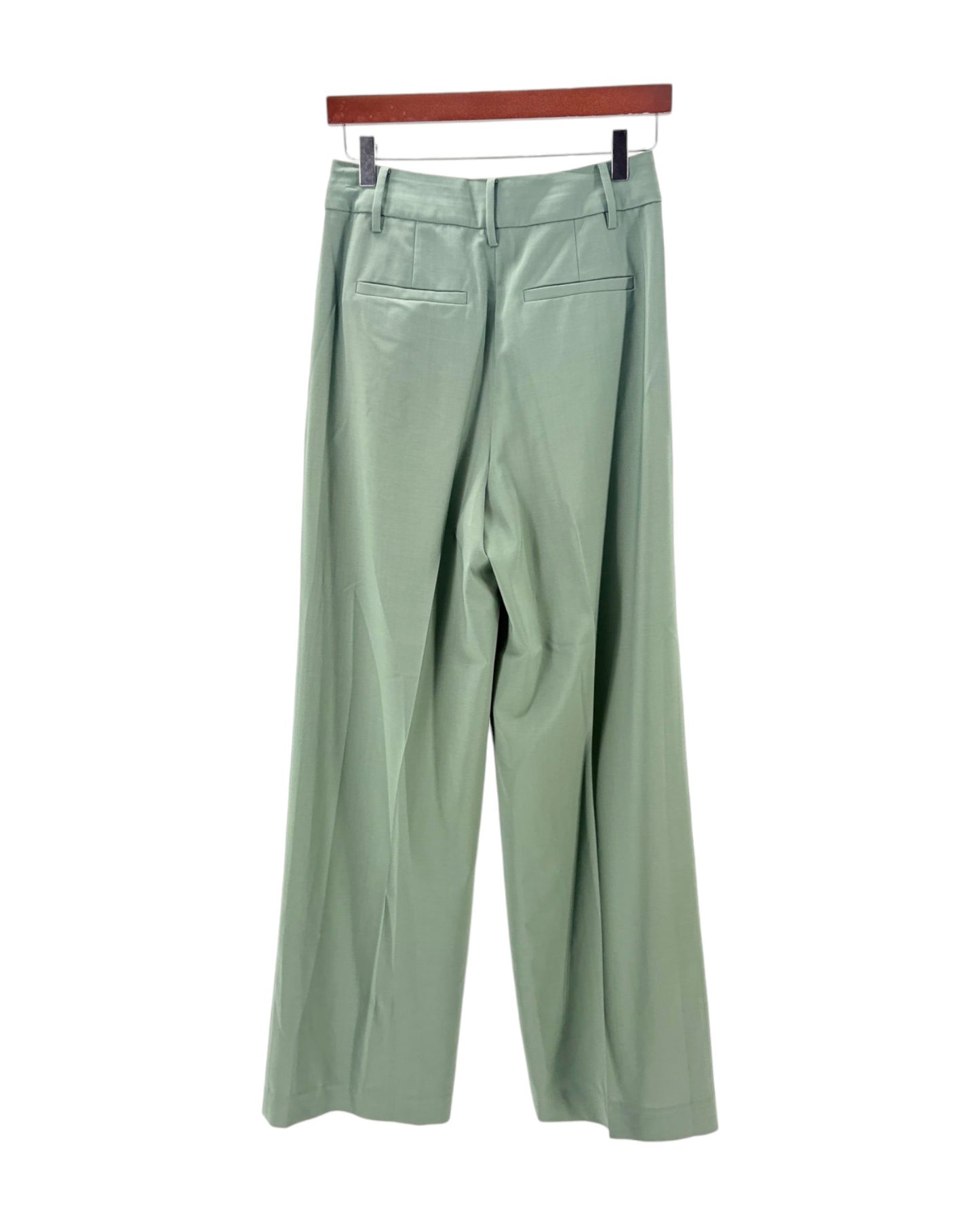 Light green pants on a hanger against a white background