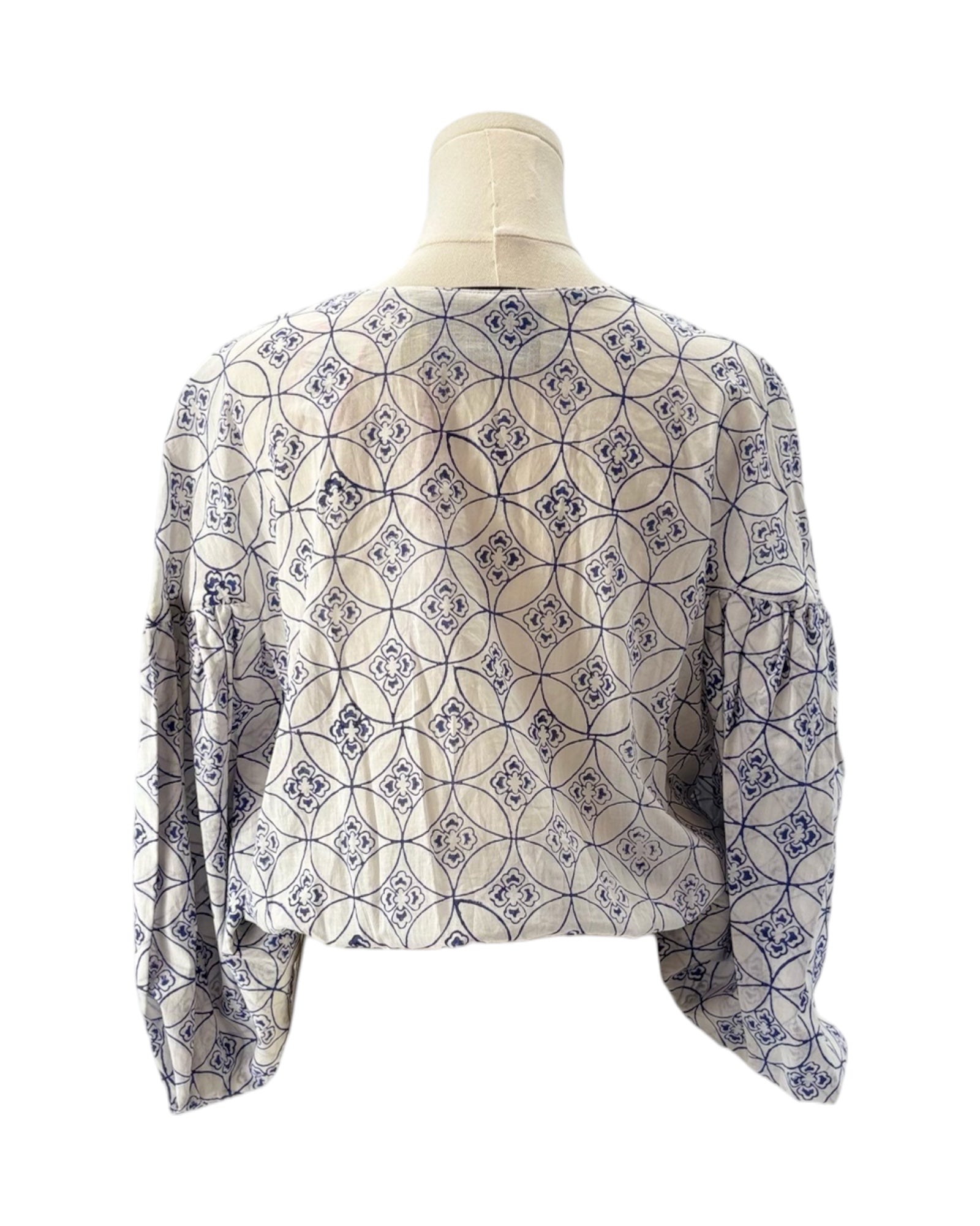 Patterned blouse on a mannequin against a white background