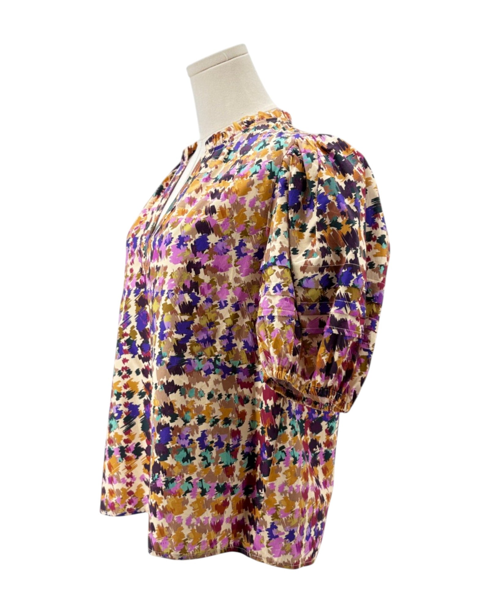 Multicolored floral blouse on a mannequin against a white background