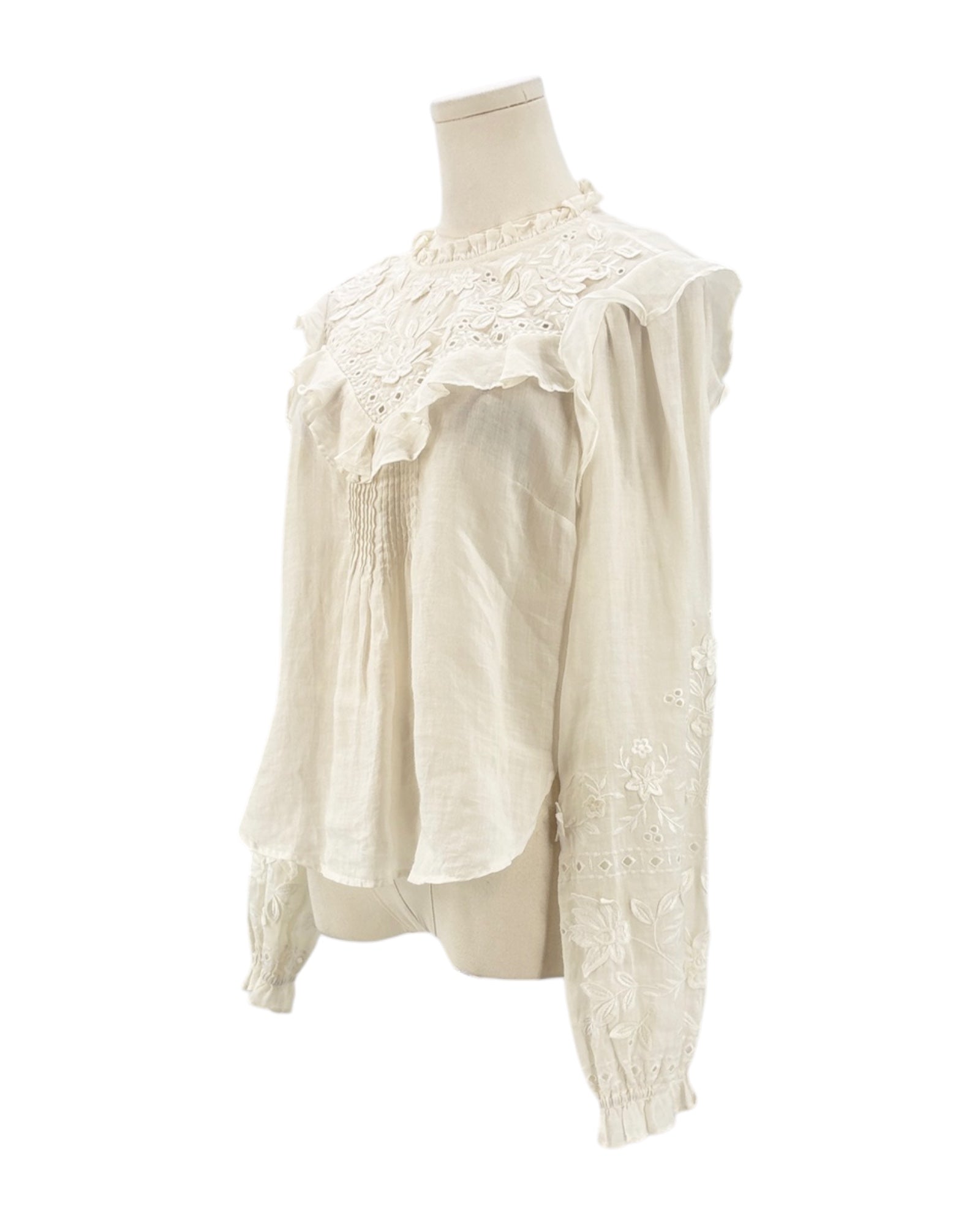 White lace blouse on a mannequin against a white background