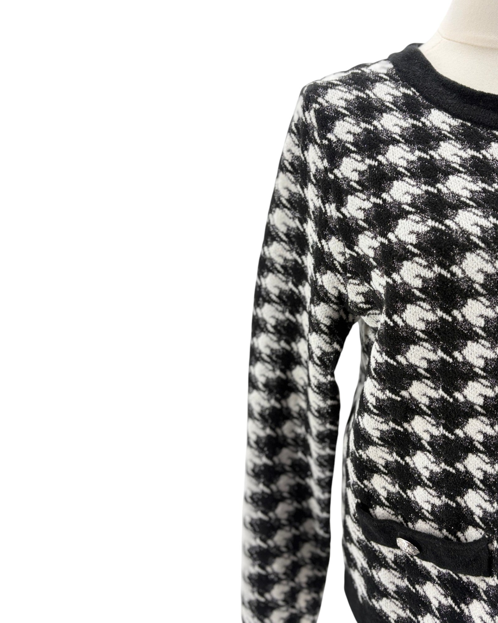 Black and white checkered sweater on a mannequin against a white background