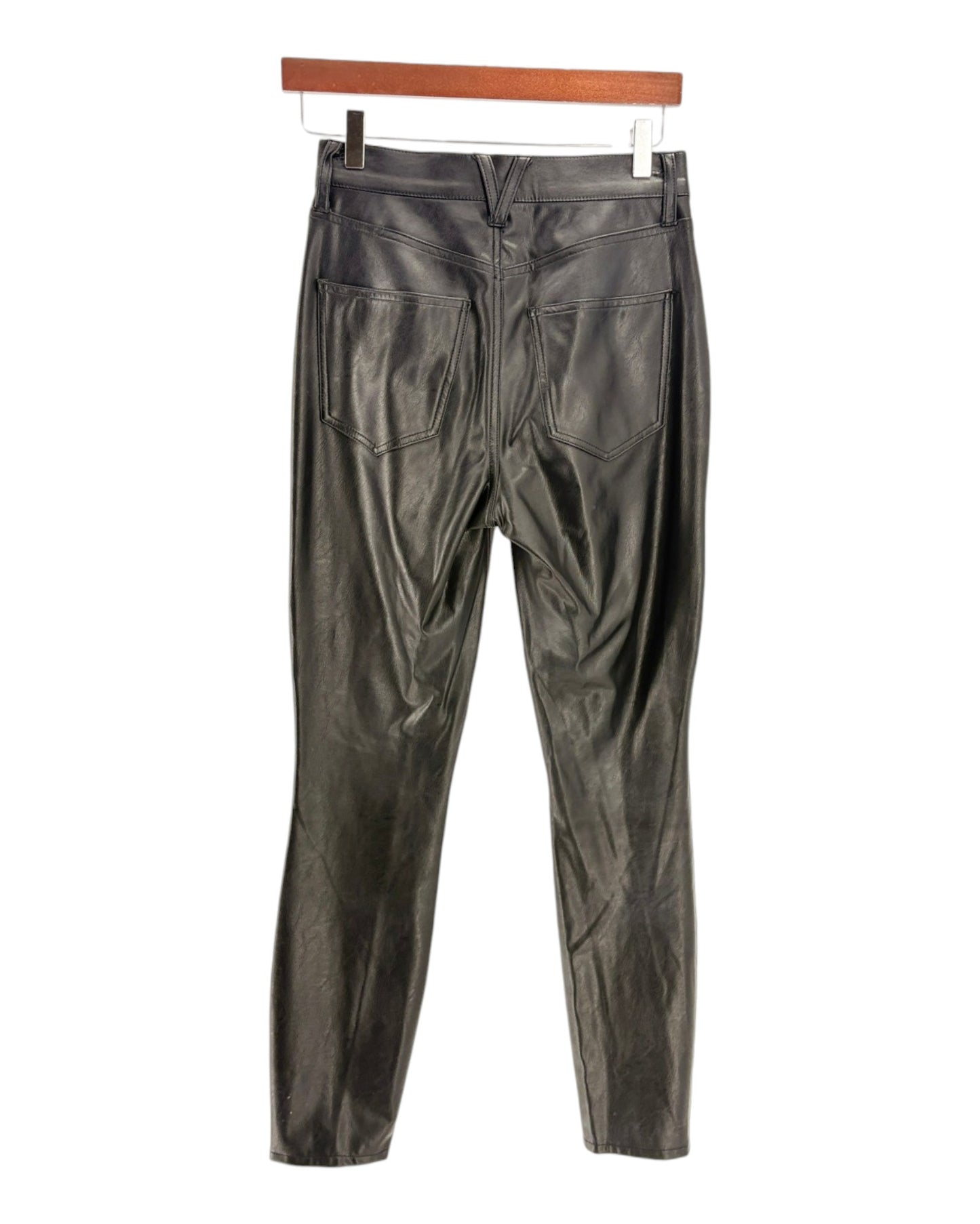 Black leather pants on a hanger against a white background