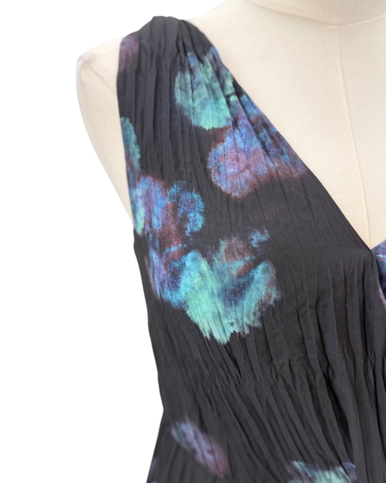 Black dress with colorful floral patterns on a mannequin against a white background