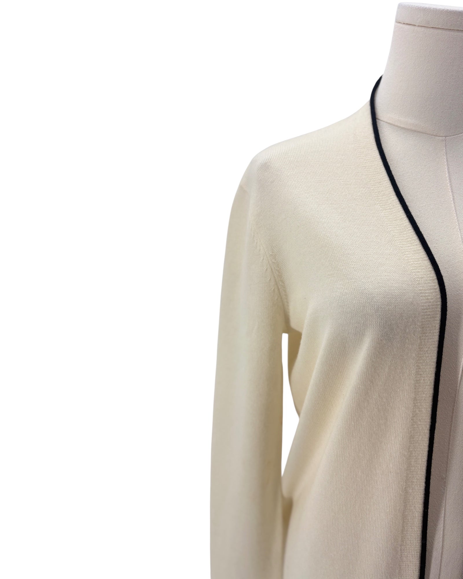 Cream cardigan with black trim on a mannequin against a white background