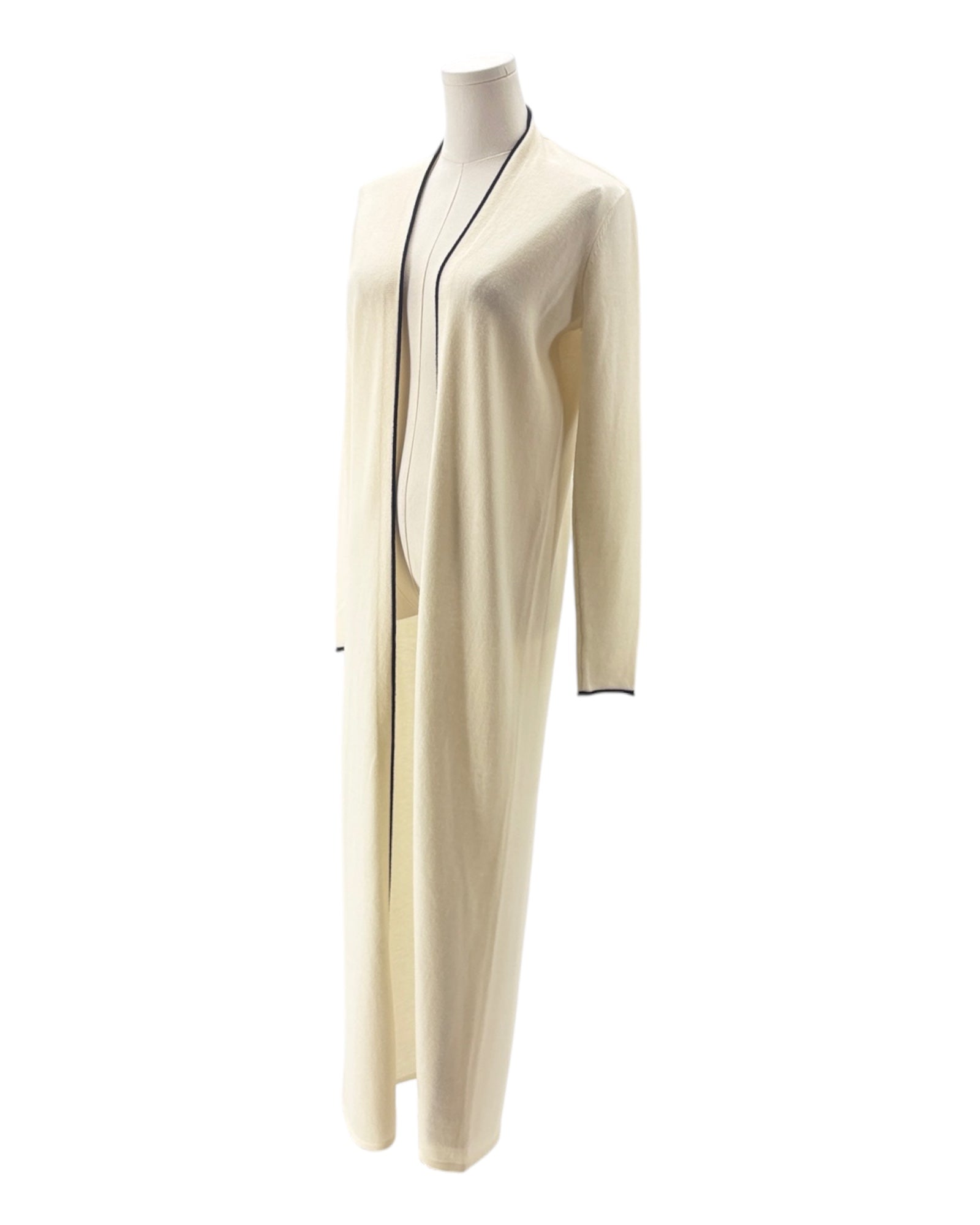 Long cream-colored dress with black trim on a mannequin against a white background