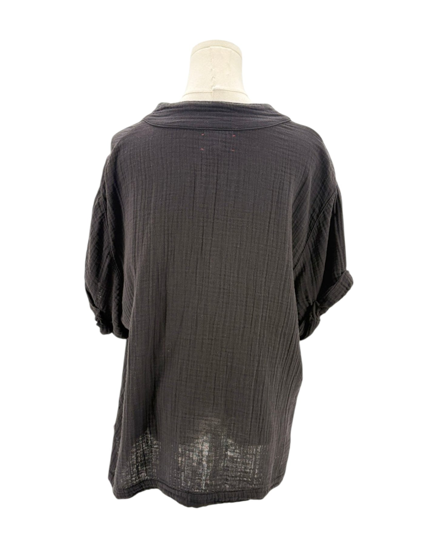 black textured blouse on a mannequin against a white background