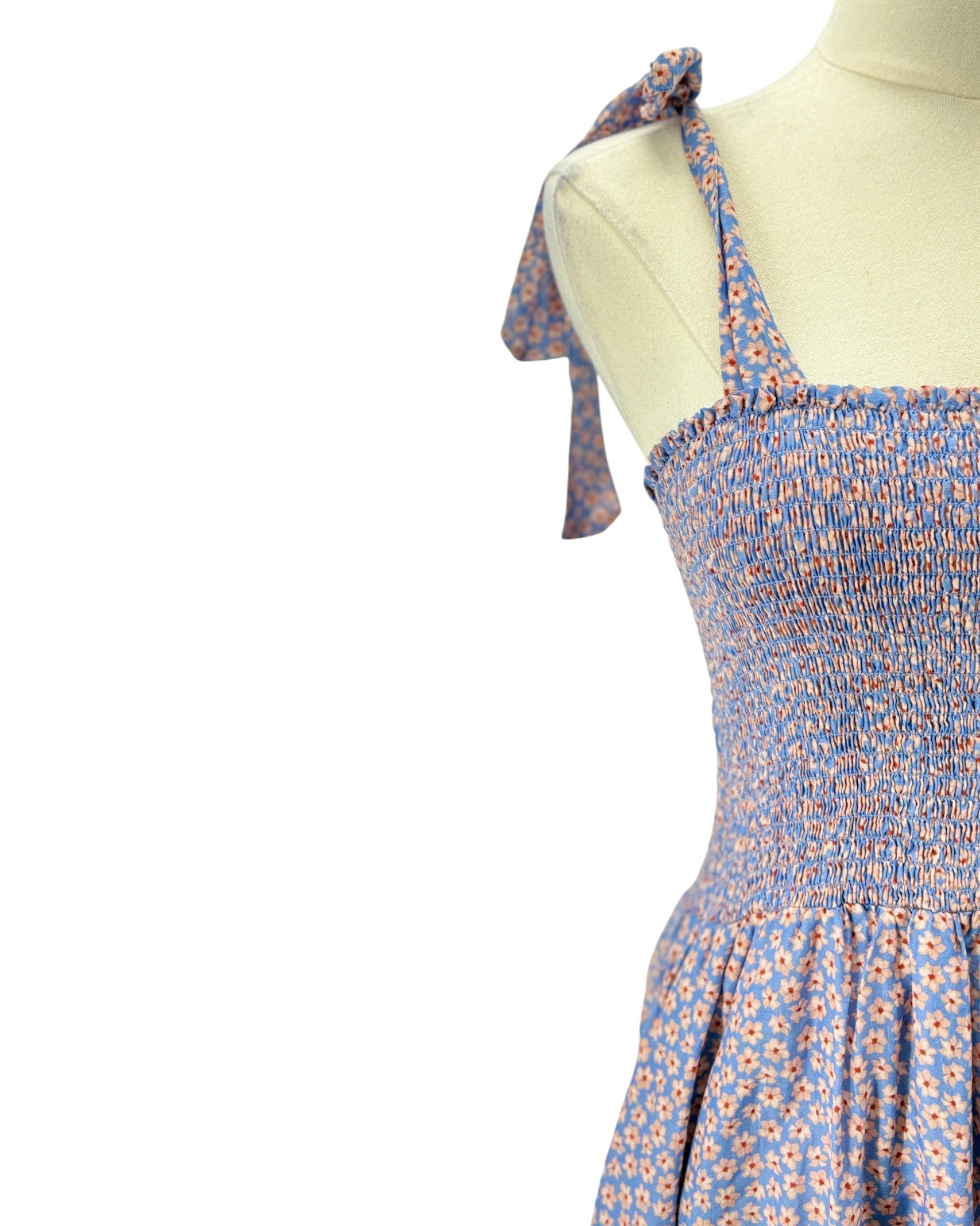 Blue floral dress on a mannequin with a white background