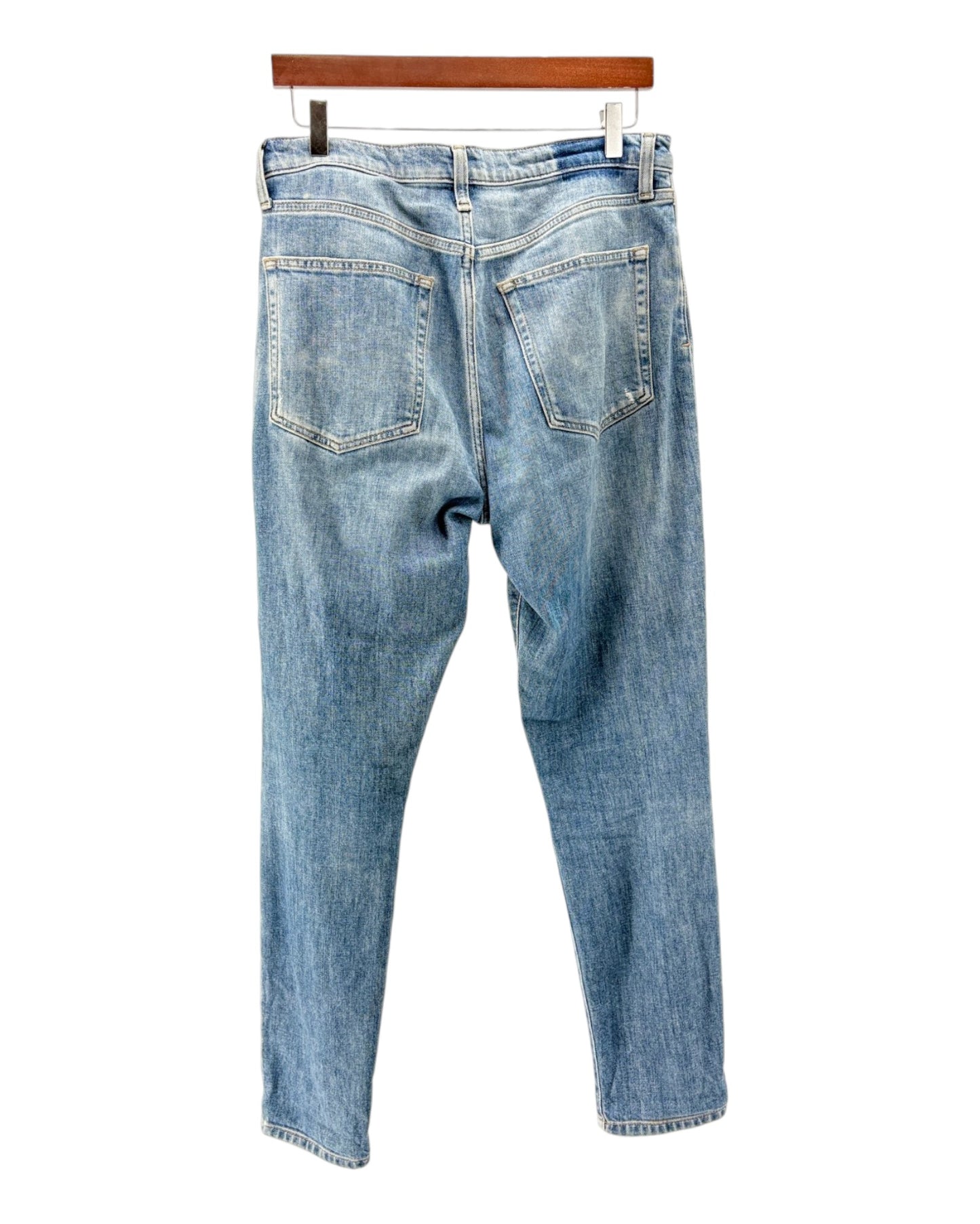 Blue jeans on a hanger against a white background