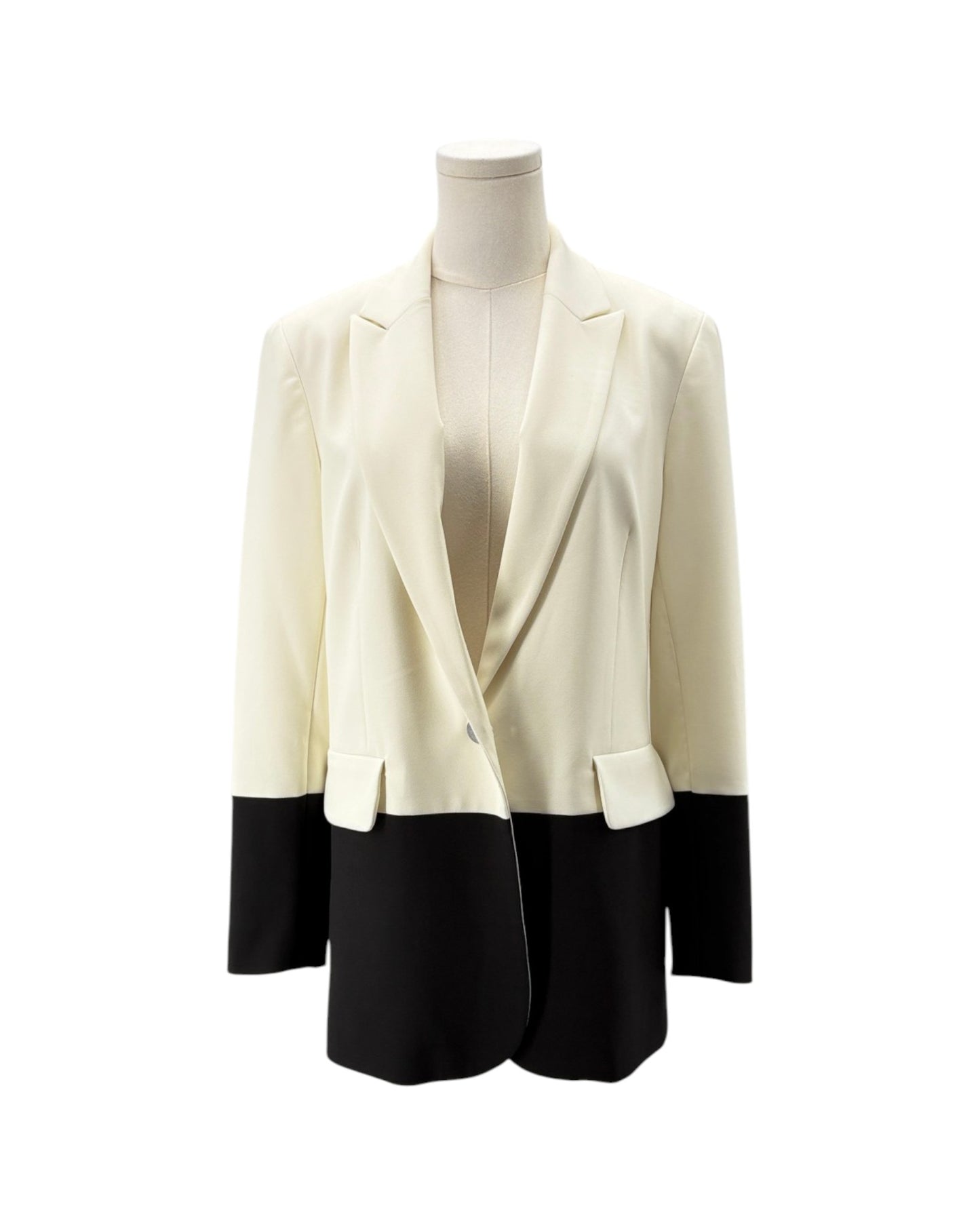 A color-block blazer jacket displayed on a mannequin torso against a plain white background. The upper portion is cream-colored, and the lower portion and sleeve cuffs are black.