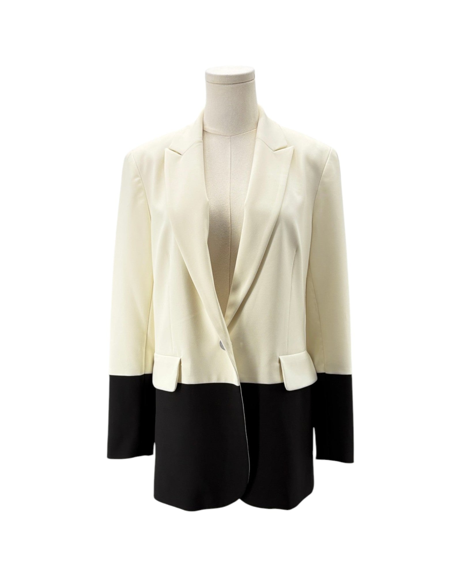 A color-block blazer jacket displayed on a mannequin torso against a plain white background. The upper portion is cream-colored, and the lower portion and sleeve cuffs are black.