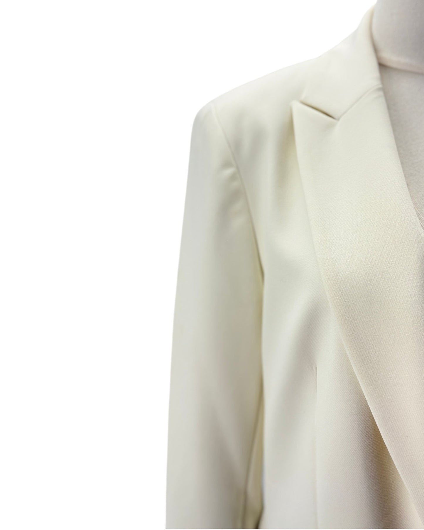 Close-up of a cream-colored blazer jacket on a mannequin torso against a plain white background.