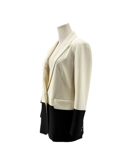 A women's blazer jacket with a color-blocked design, featuring an off-white/cream upper body and sleeves with black lower panels and cuffs, displayed on a mannequin torso against a white background.