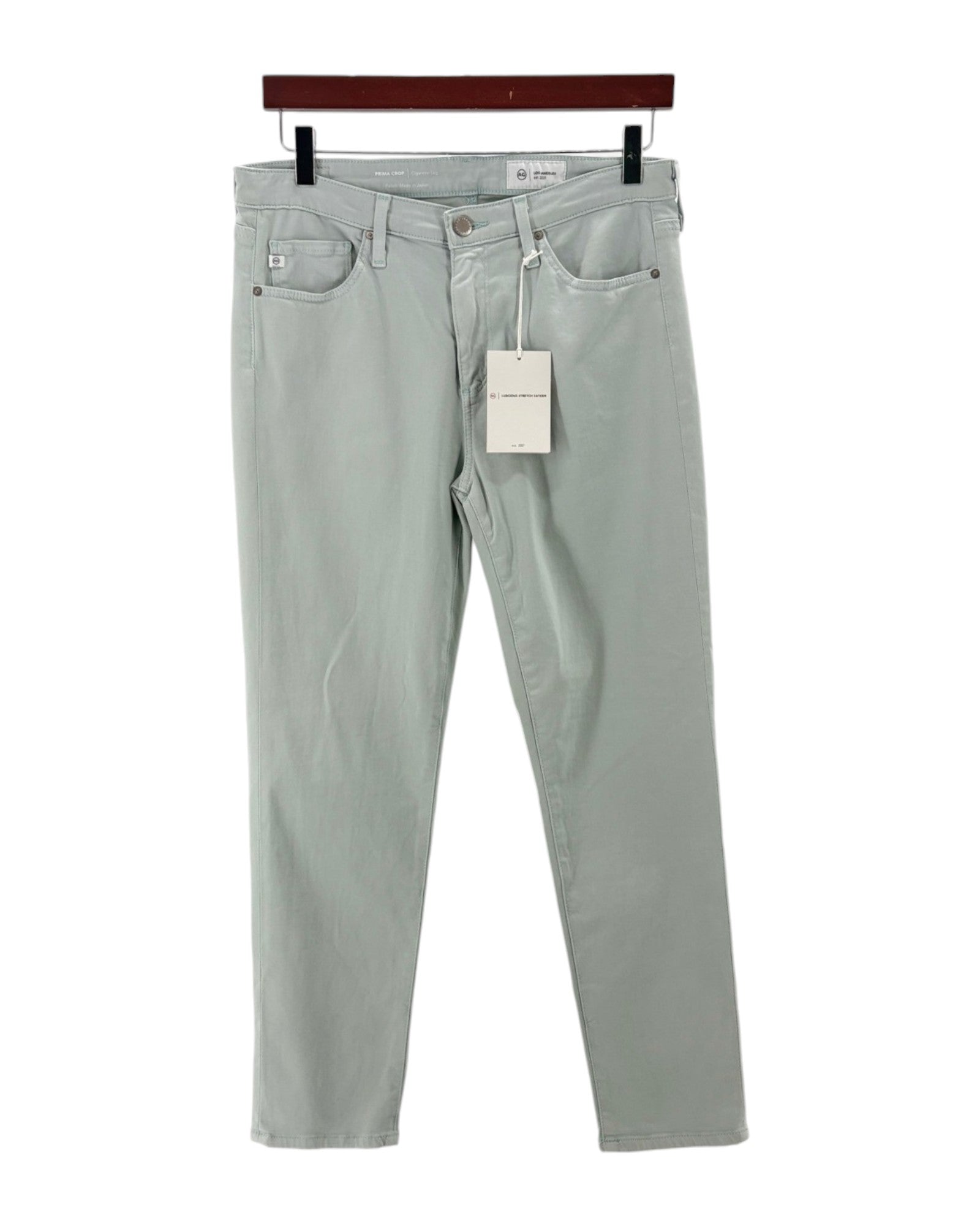 Light blue jeans with a tag on a white background