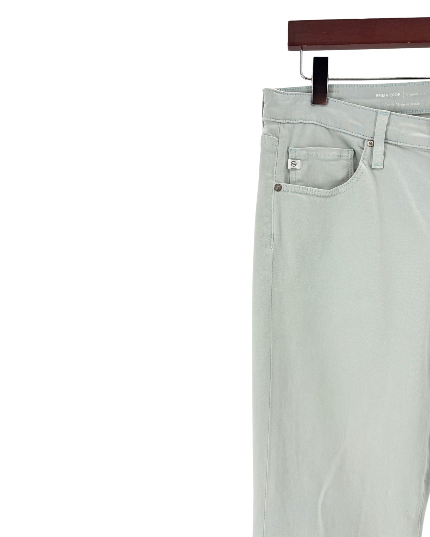 Light blue pants on a hanger against a white background