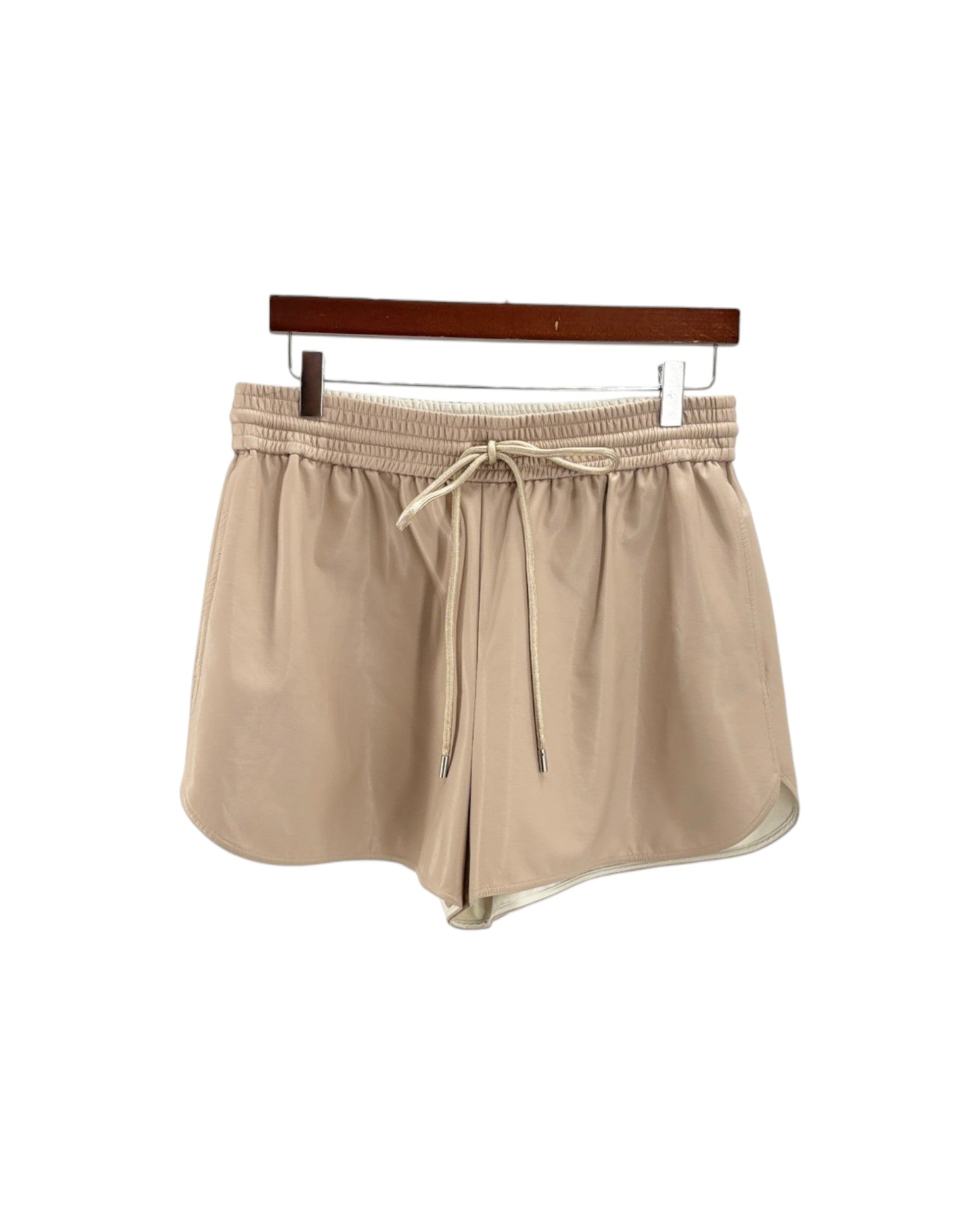 Beige shorts on a hanger against a white background