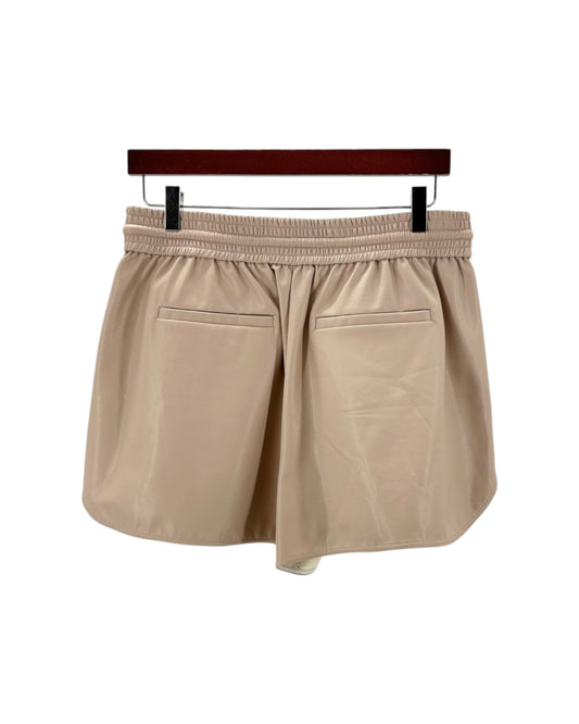 Beige shorts on a hanger against a white background