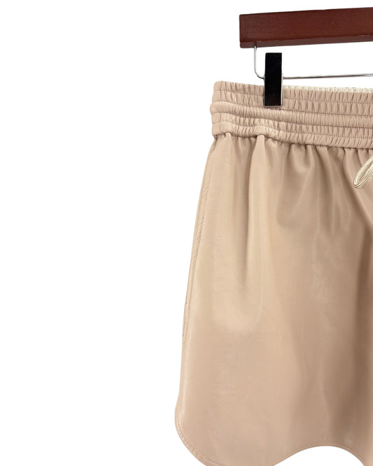 Beige shorts on a hanger against a white background