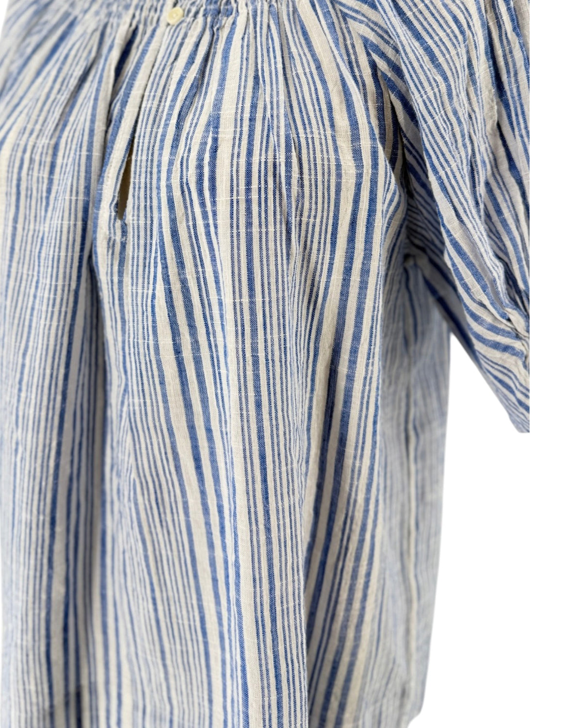 Blue and white gathered smocking at neckline, keyhole opening with button closure, dolman puff sleeve with gathered ruffle at cuff on a mannequin on a white background