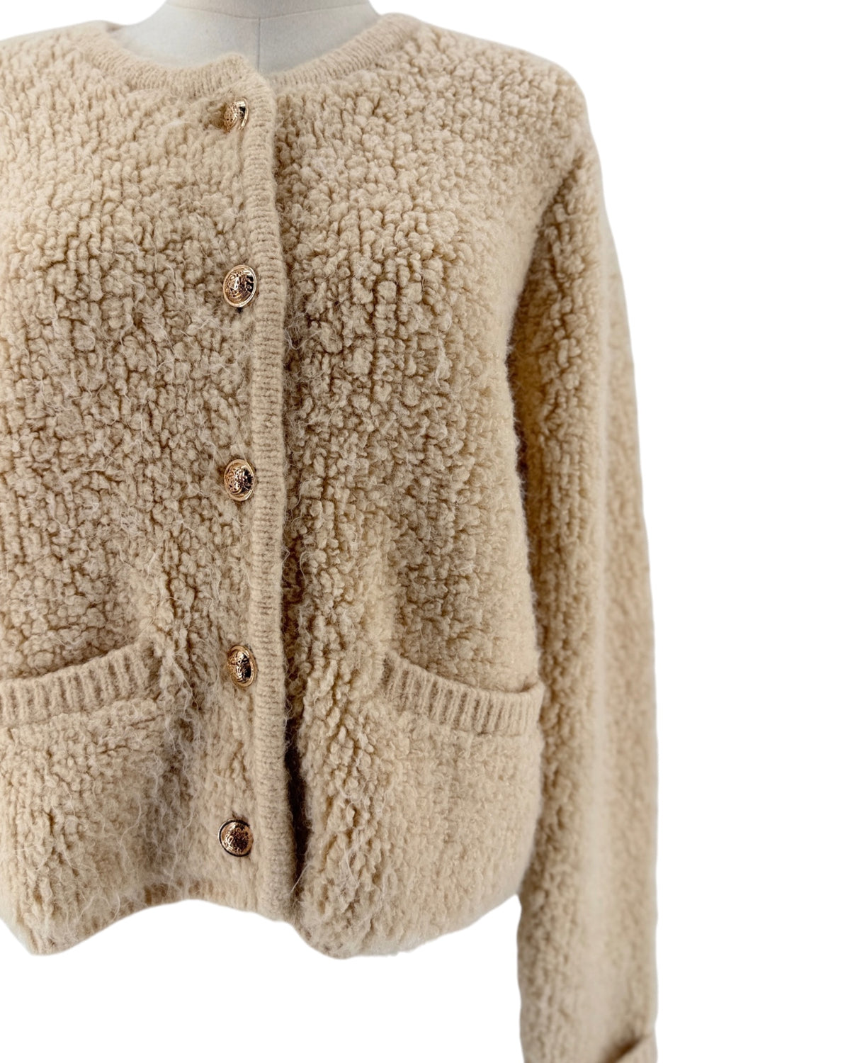 Beige Shaggy loop knit fabric, classic crewneck neckline, metallic button front closure, ribbed trim along the hem and cuffs, two front welt pockets cardigan on white background on a mannequin