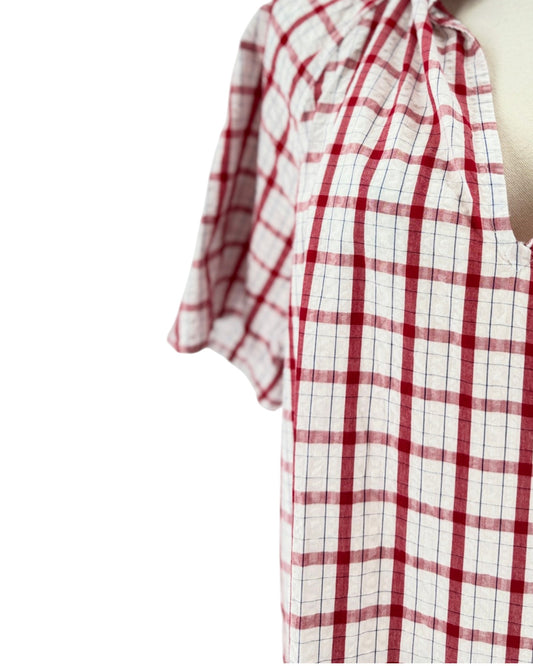 Red and white checkered with metallic threads short sleeve, side slits, split v-neckline, high ruffled collar trimmed with contrasting multi-colored striped ribbon on a mannequin on a white background