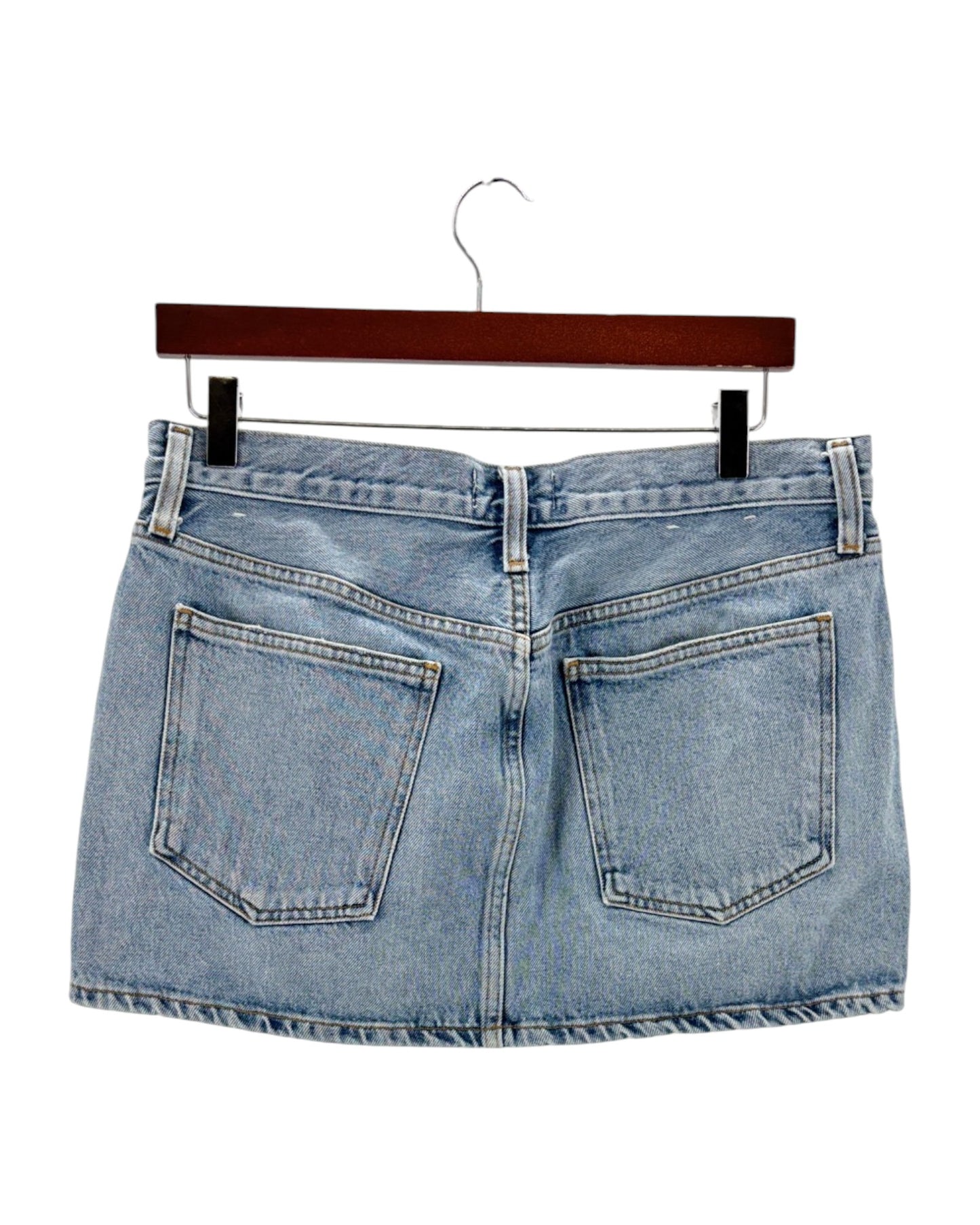 Blue denim skirt on a hanger against a white background