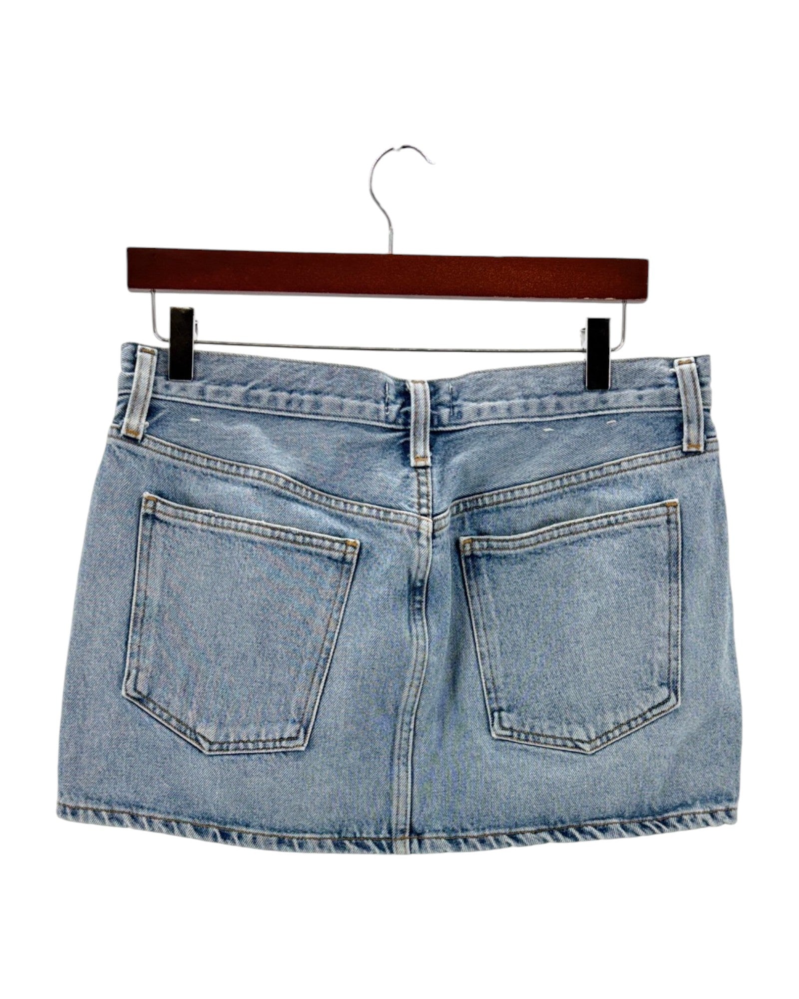 Blue denim skirt on a hanger against a white background