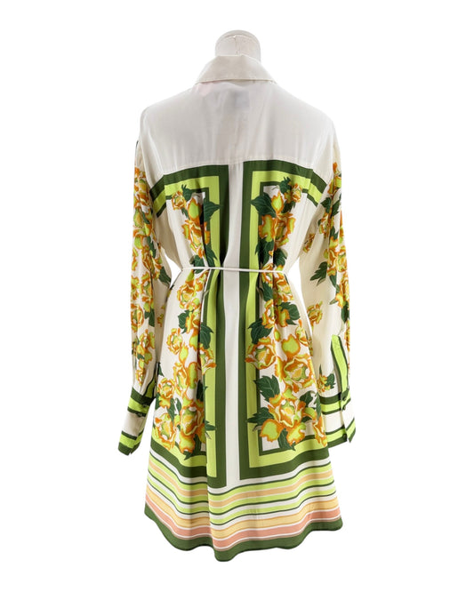 Mannequin wearing a patterned dress with green, yellow, and white design on a white background