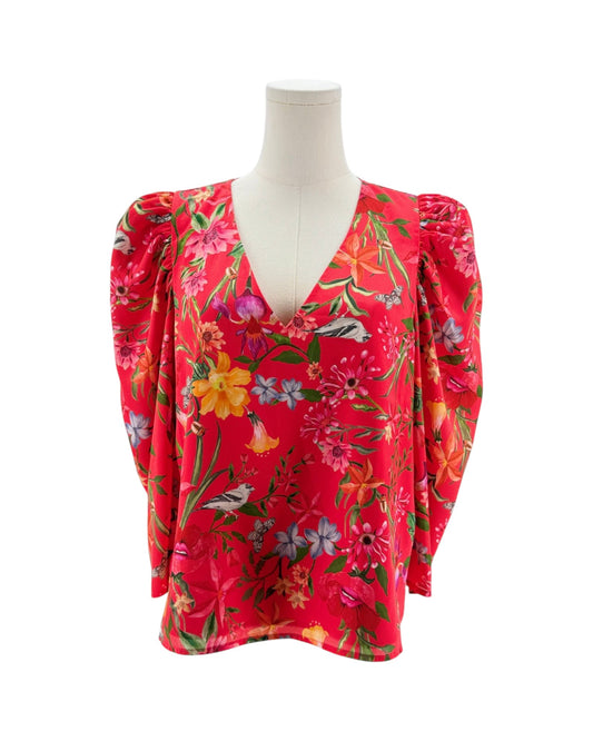 Red floral blouse on a mannequin against a white background