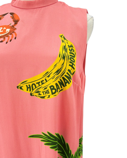 Sleeveless silk dress with tropical design on a mannequin against a white background