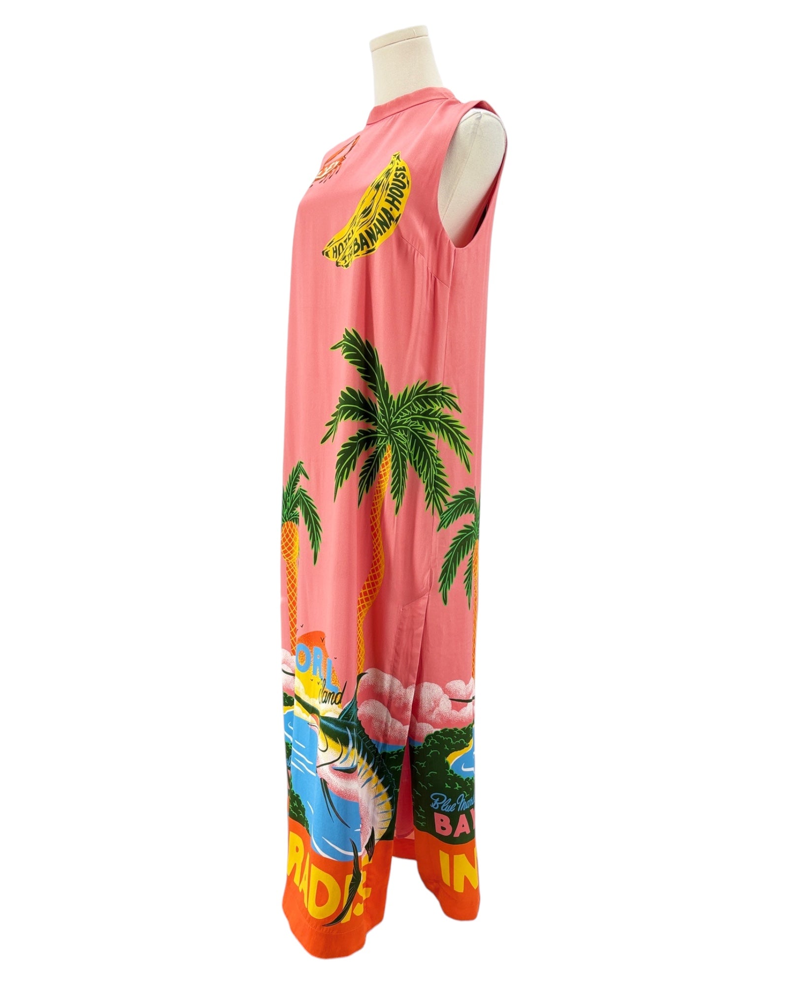 Sleeveless silk dress with tropical design on a mannequin against a white background
