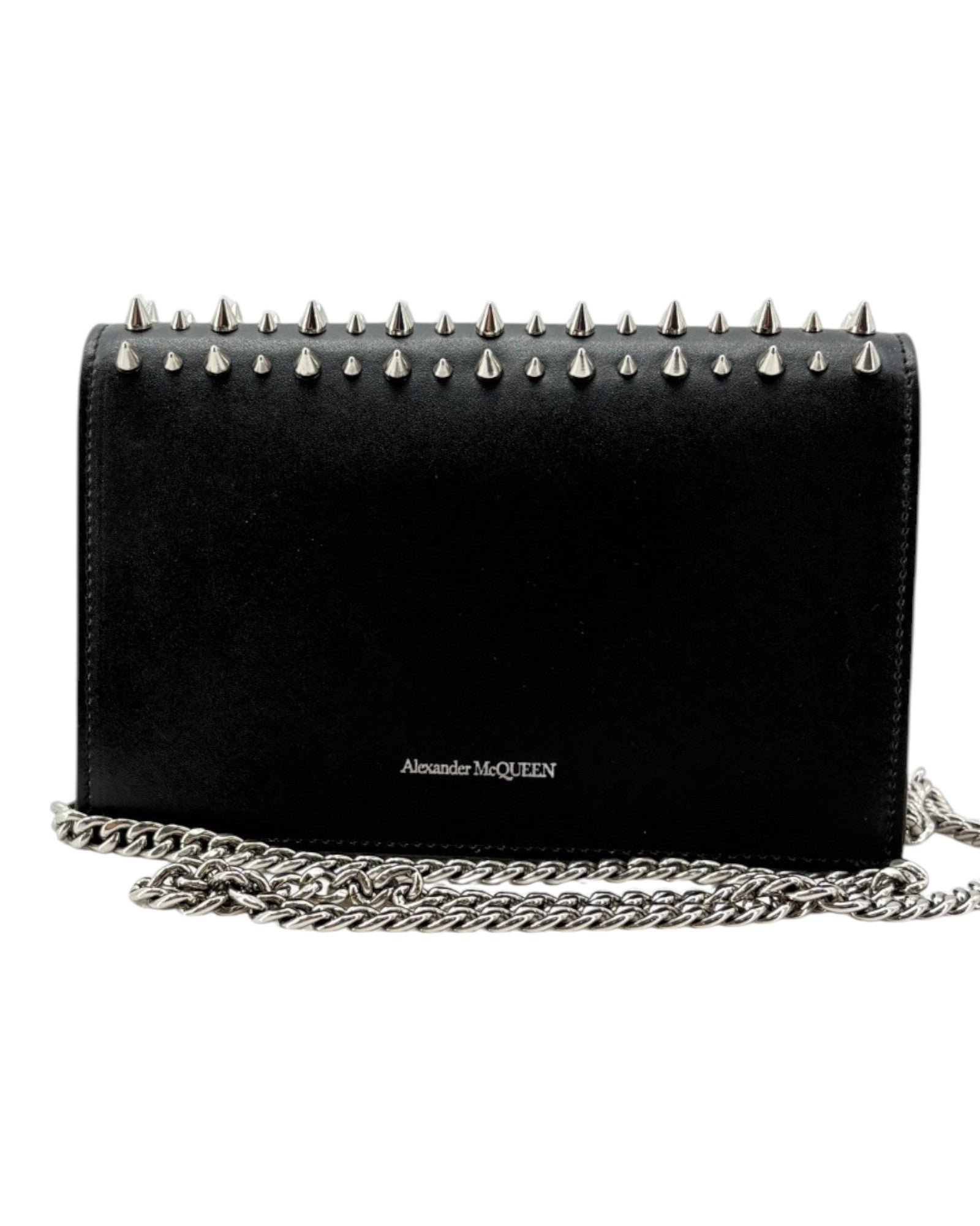 Black handbag with spike details and chain strap on a white background