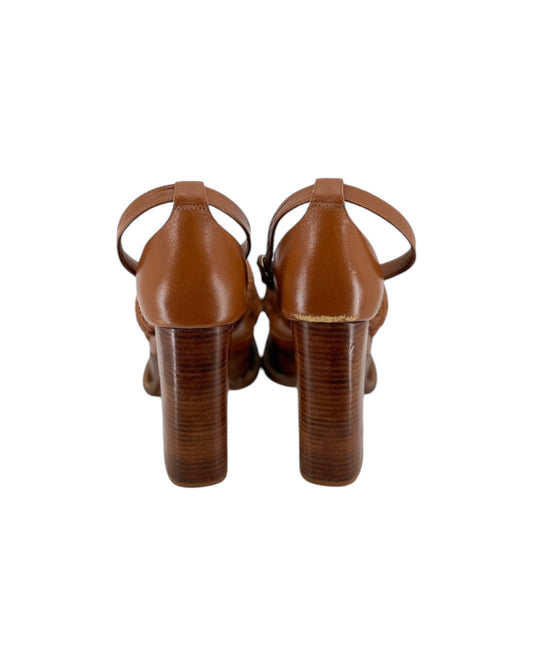 A pair of women's block-heel sandals in a warm cognac brown leather, shown from the back on a plain white background.