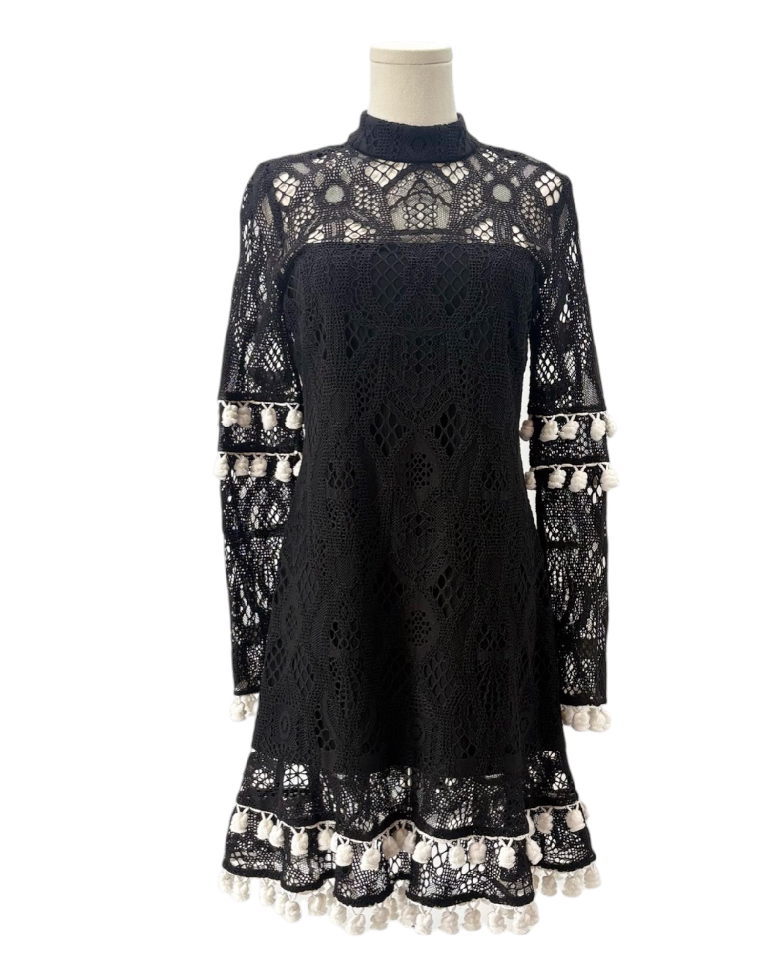 Black lace dress with long sleeves on a mannequin against a white background