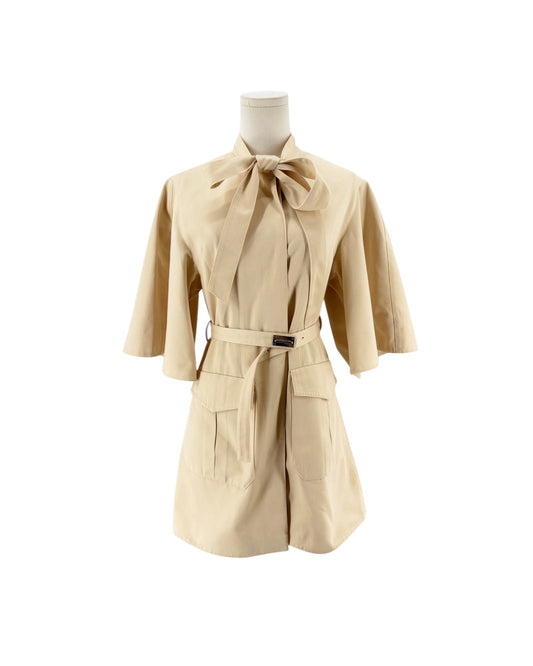 3/4 length beige mini dress with a oversized bowtie neckline and a matching belt with silver hardware on a white background on a mannequin