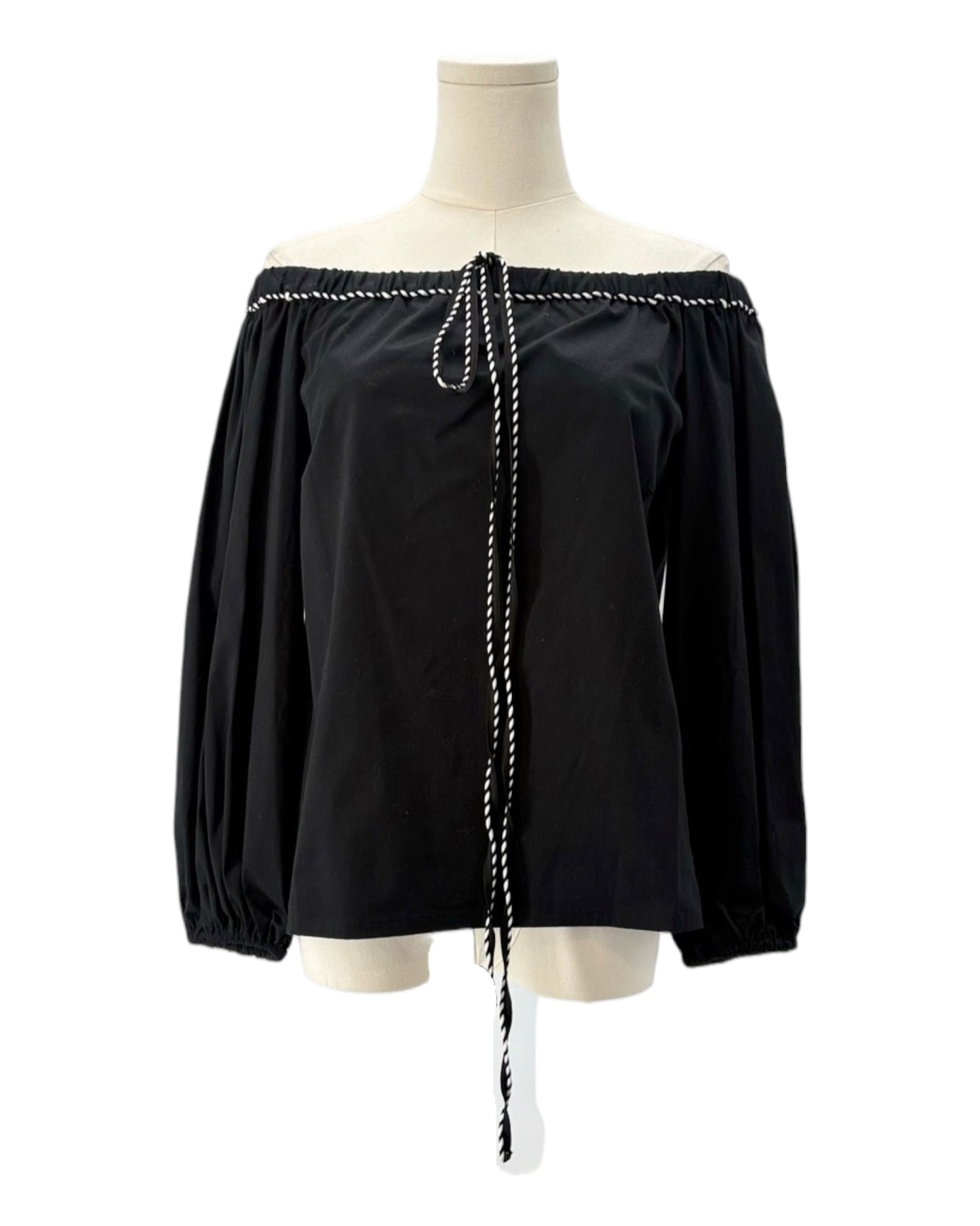 Black off-shoulder blouse with white trim on a mannequin against a white background