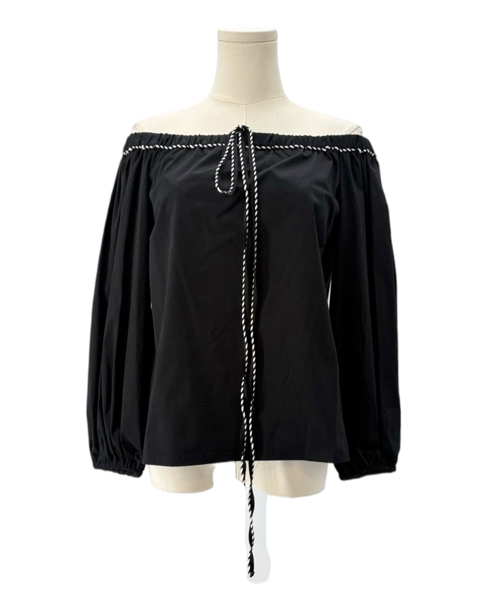 Black off-shoulder blouse with white trim on a mannequin against a white background