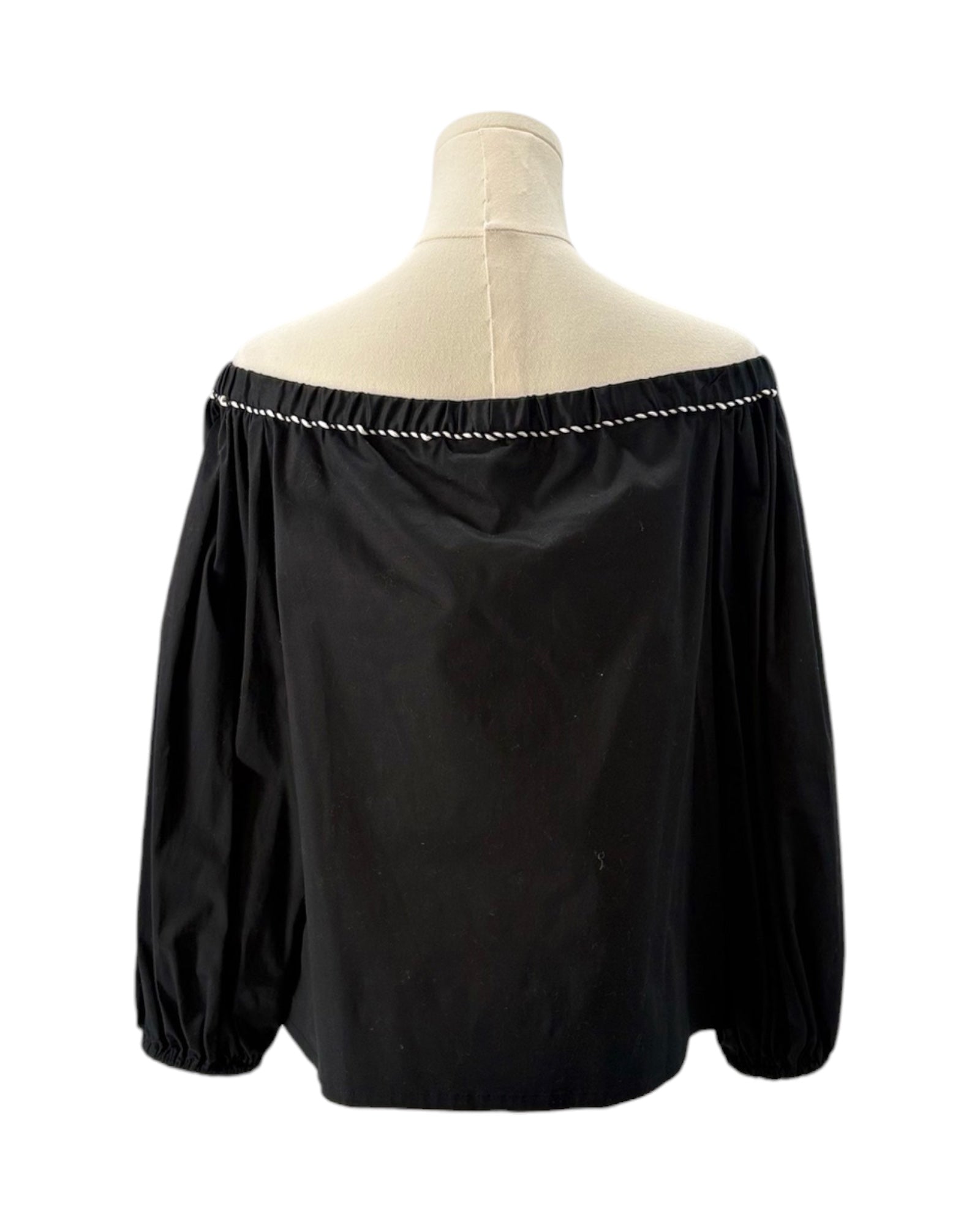 Black off-shoulder blouse on a mannequin with a white background