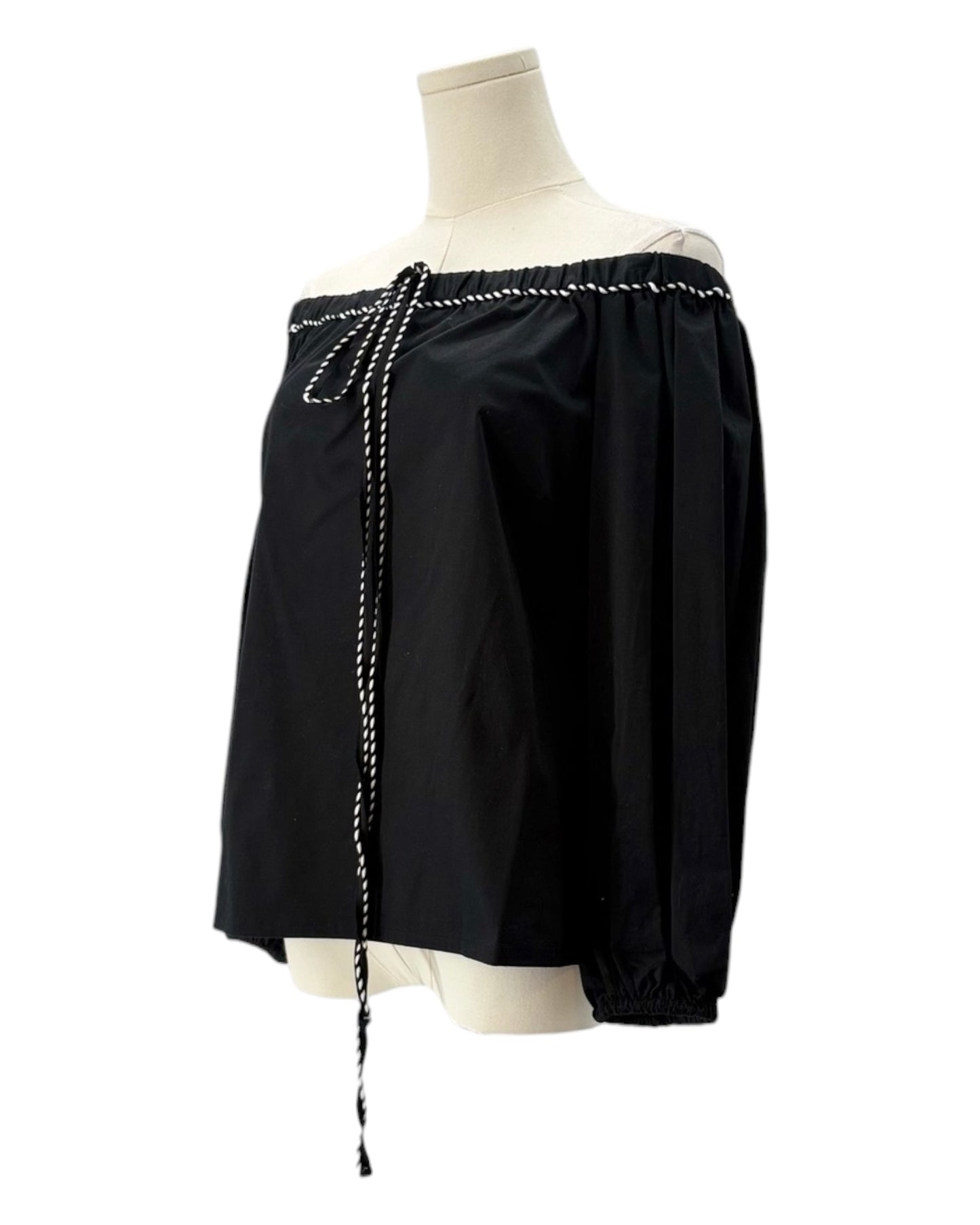 Black off-shoulder top with pearl details on a mannequin against a white background