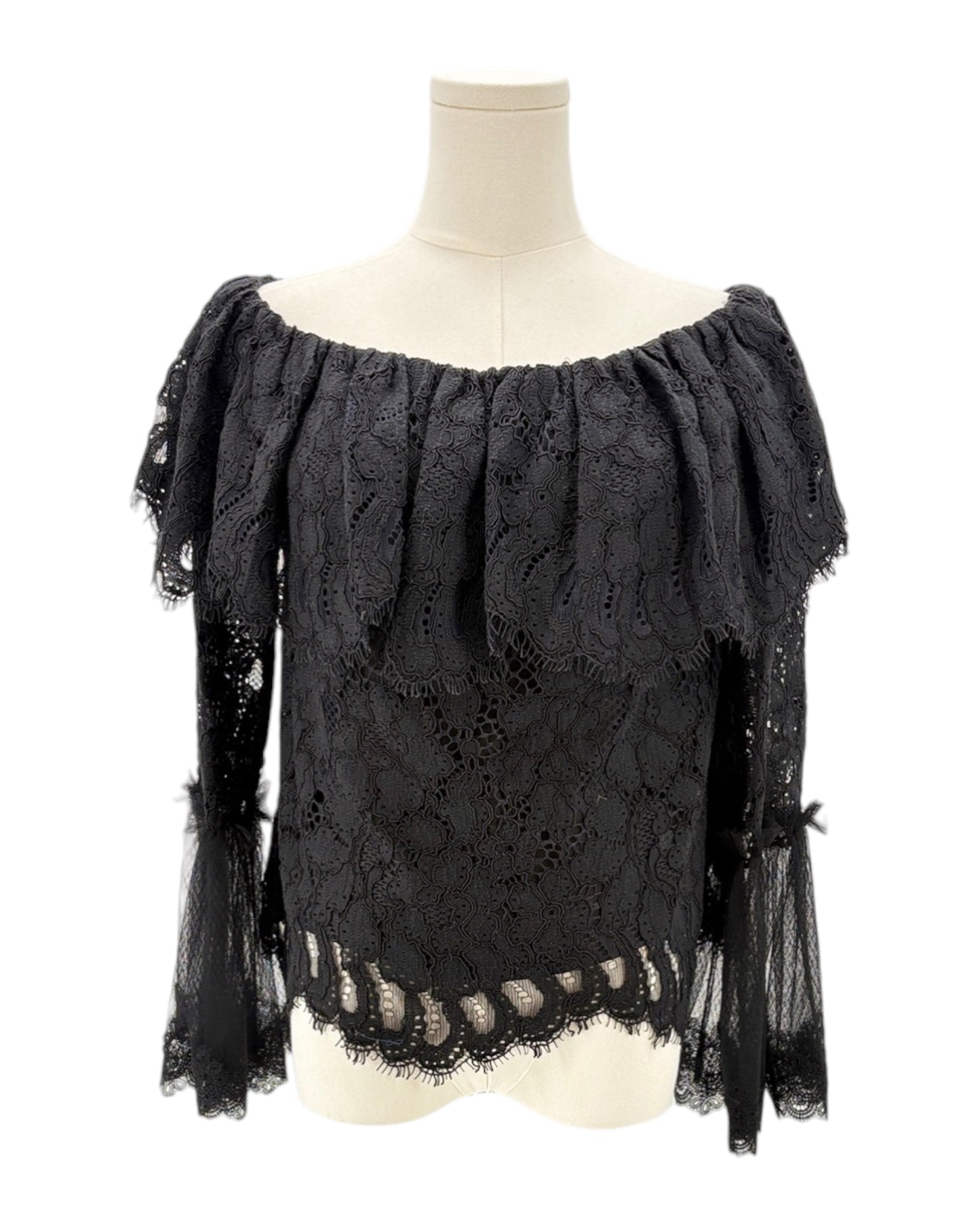 Black lace top on a mannequin against a white background