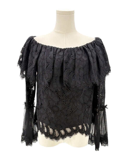 Black lace top on a mannequin against a white background