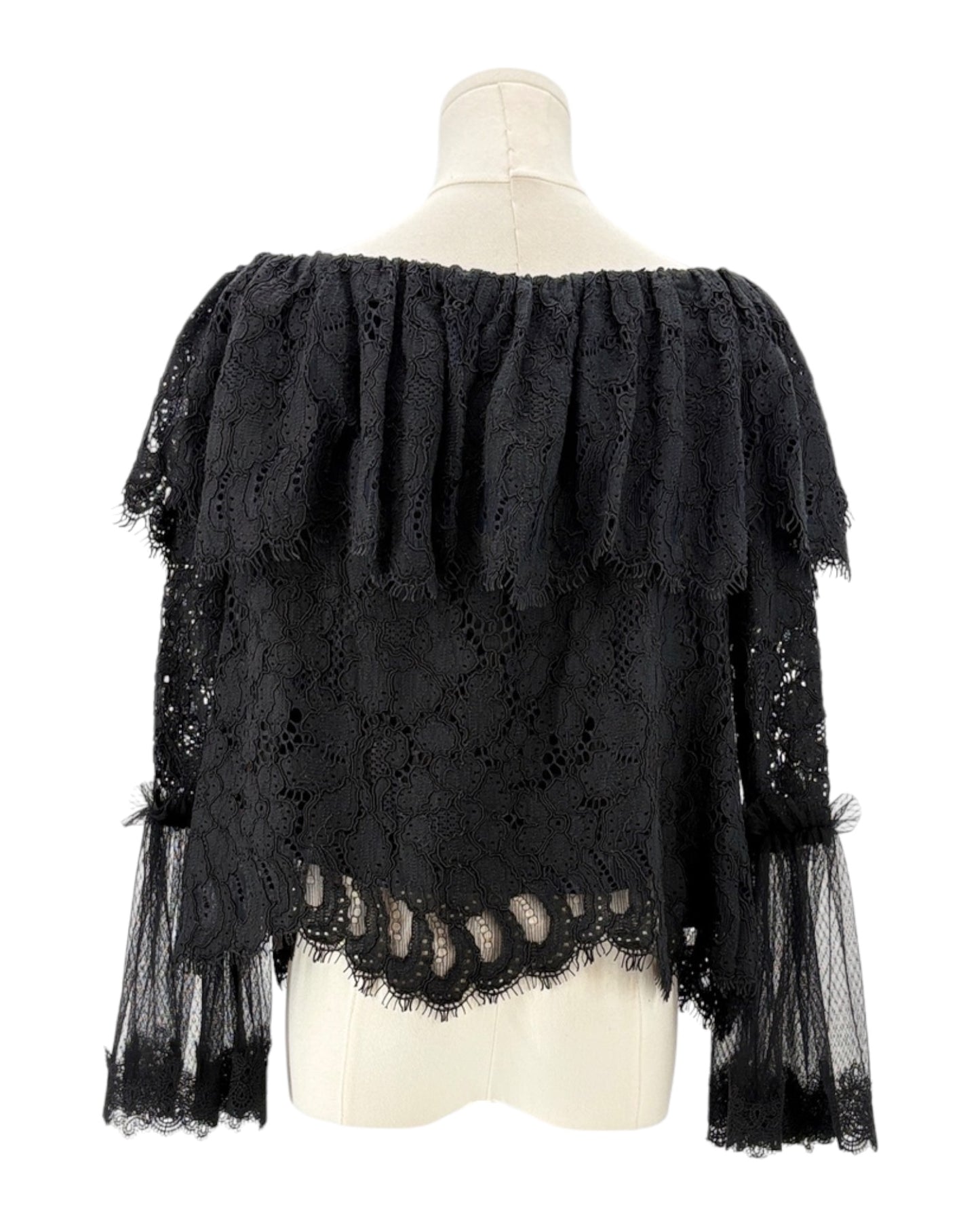 Black lace top on a mannequin against a white background