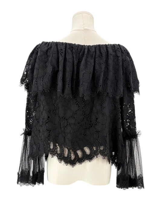 Black lace top on a mannequin against a white background