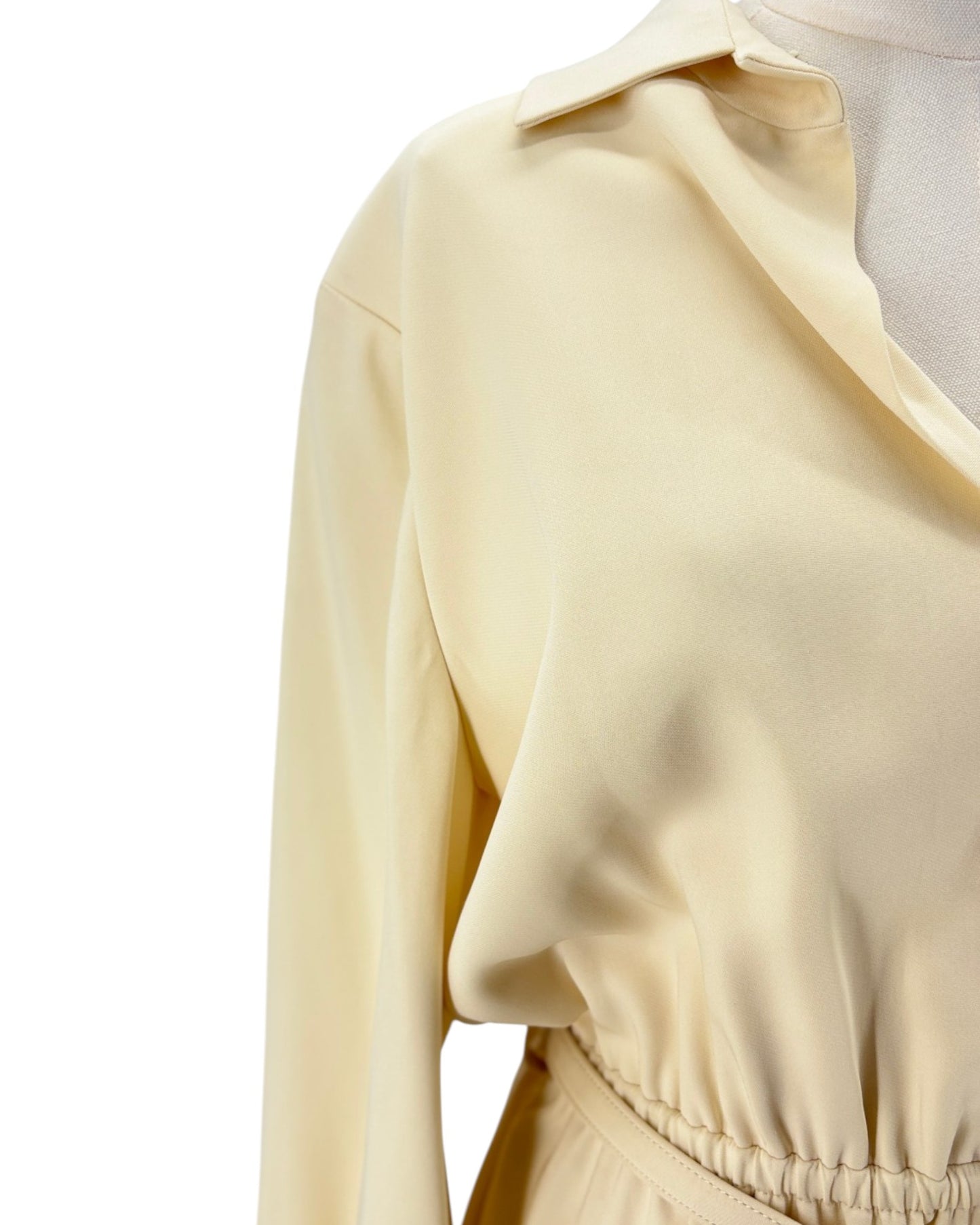 Close-up of a beige long-sleeve dress with a collar on a white background