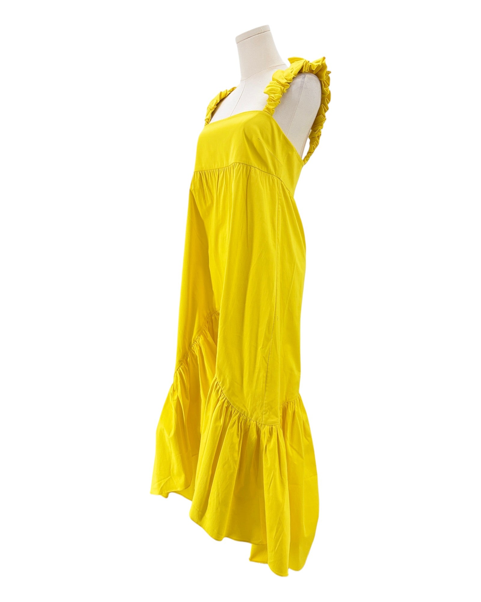 Alexis yellow dress with ruffled shoulders on a mannequin against a white background