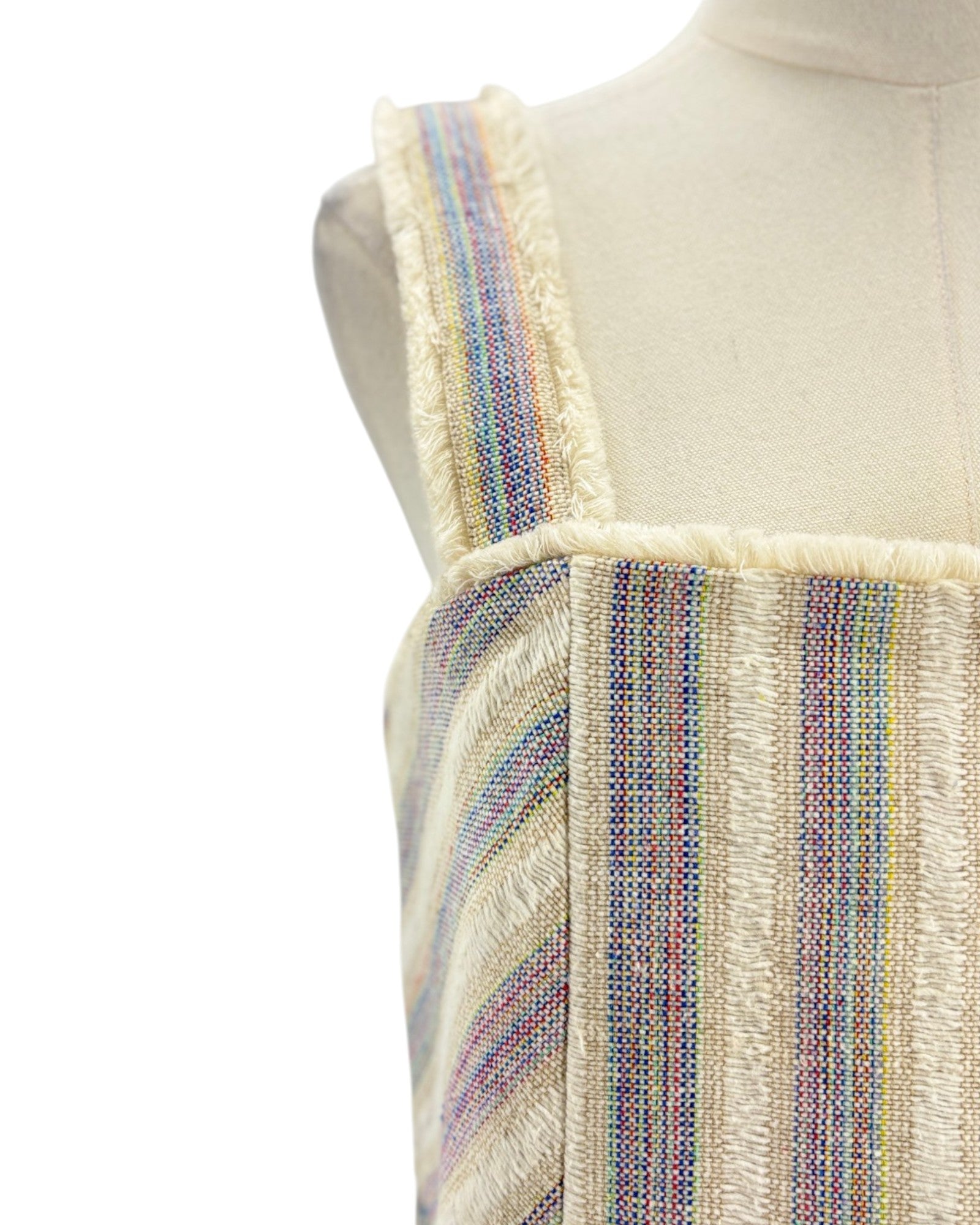 Mannequin wearing a colorful striped dress with a white background